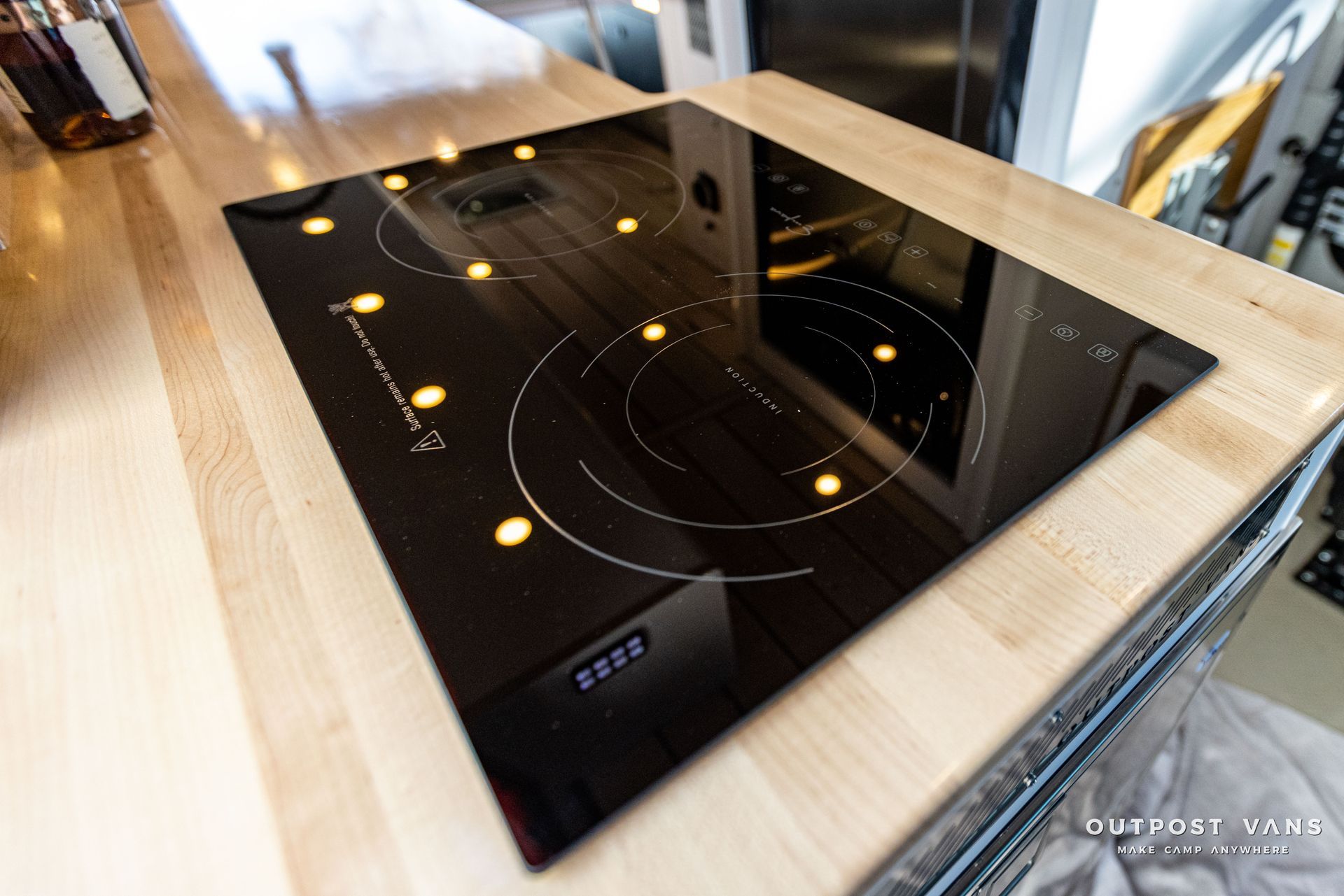 a black stove top is sitting on top of a wooden counter .