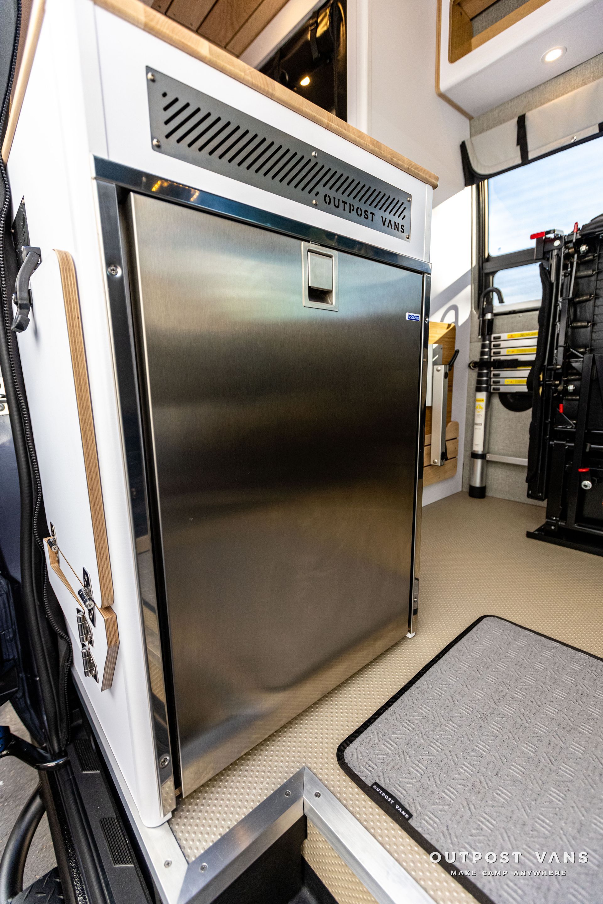 a stainless steel refrigerator is sitting in a van .