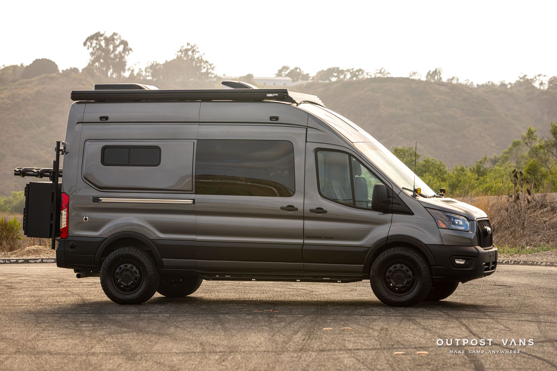 Shimmer Gray camper van parked on a gravel road with mountains in the background
