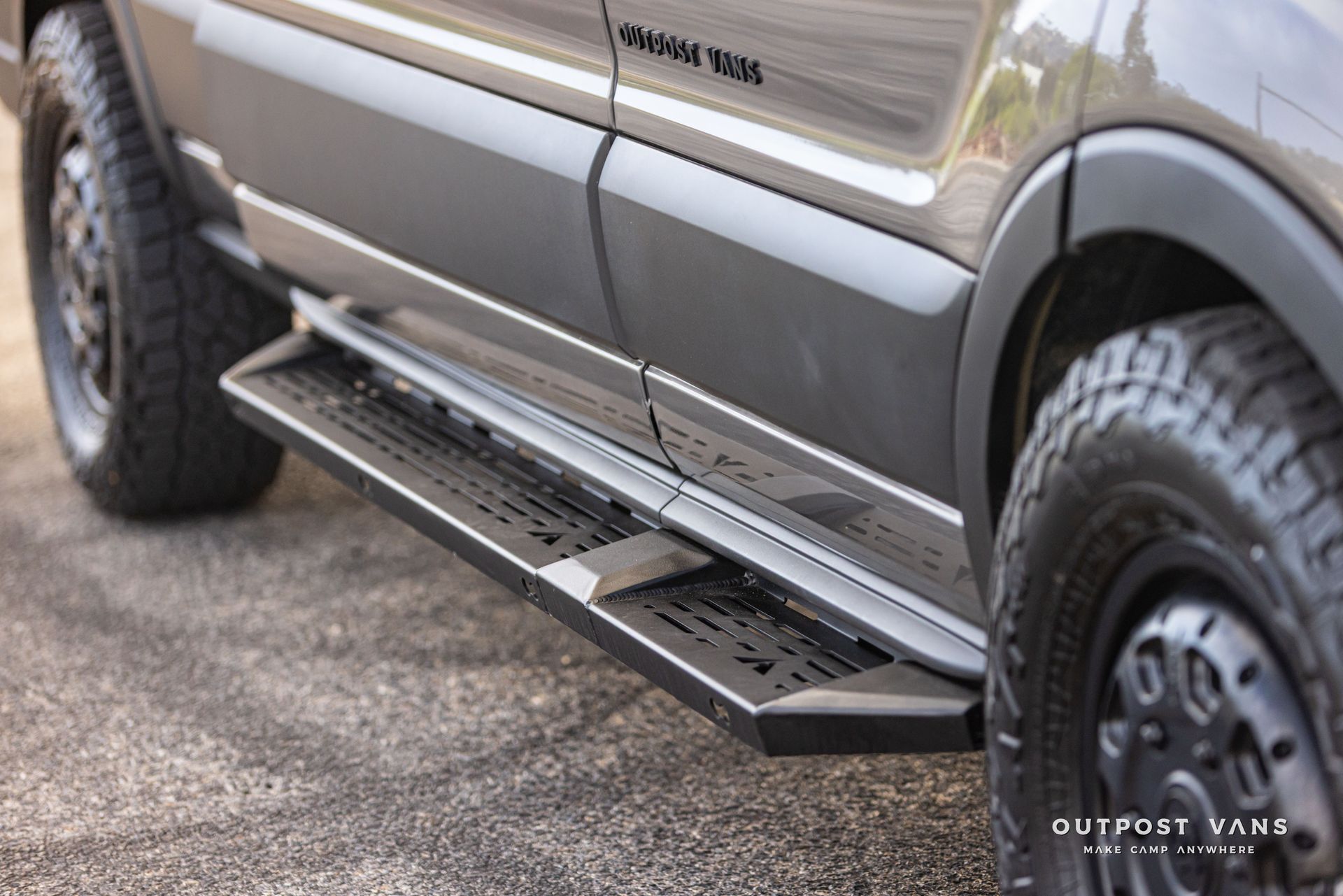 Black running board on a gray off-road pickup truck with rugged tires and folded step.