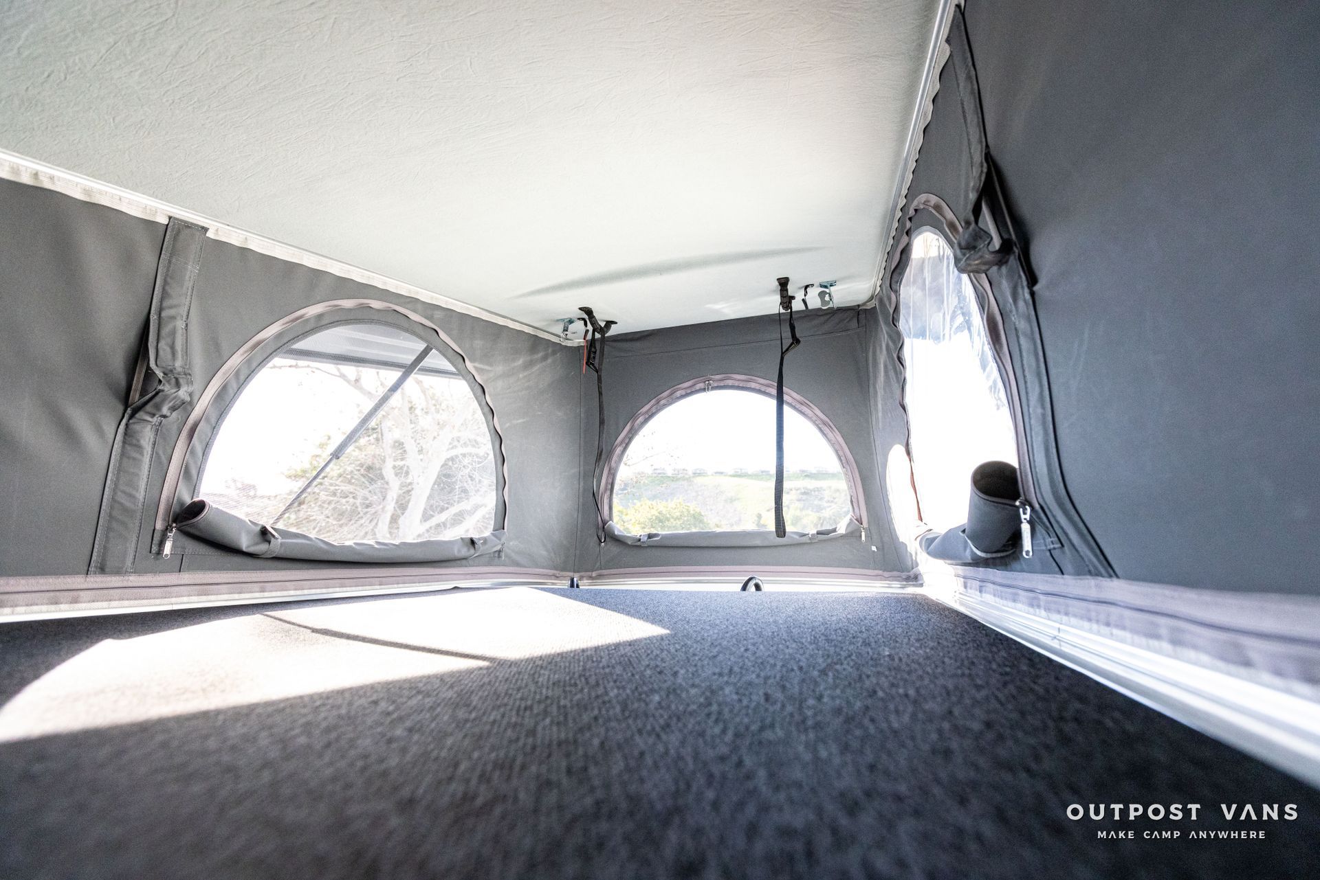 The inside of a camper van with a tent on top of it.