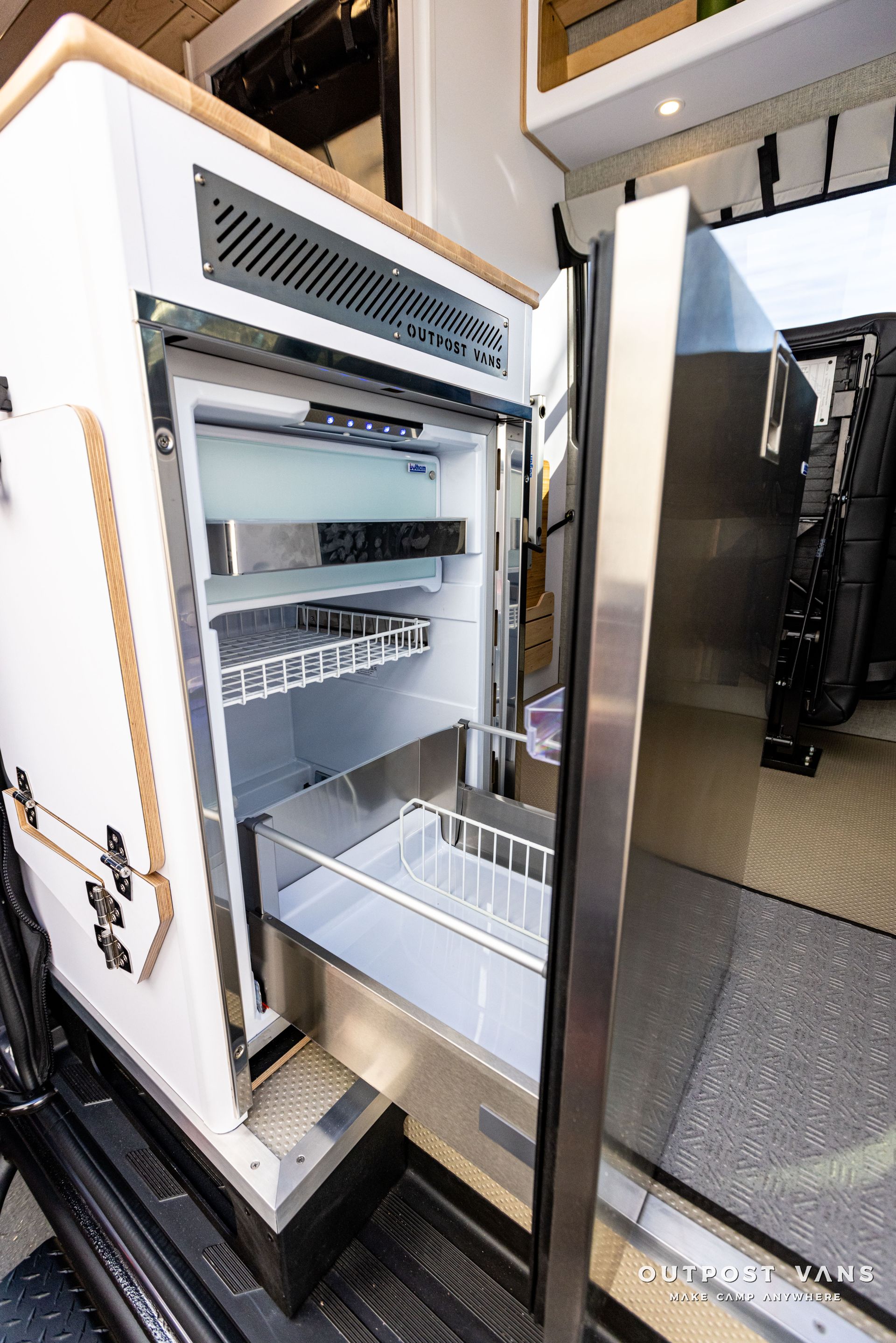 a stainless steel refrigerator with the door open in a van .