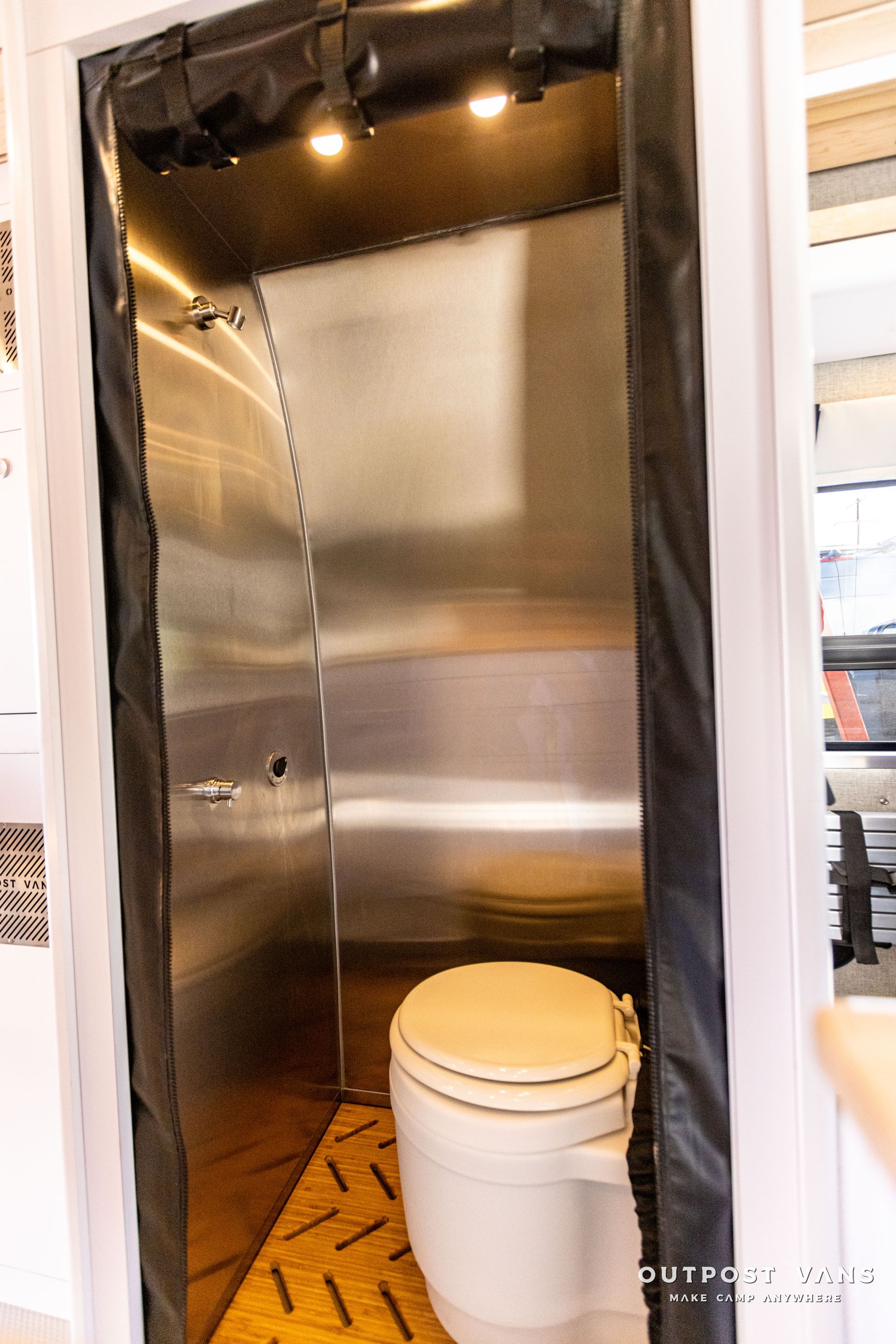 a bathroom with a toilet and a stainless steel door