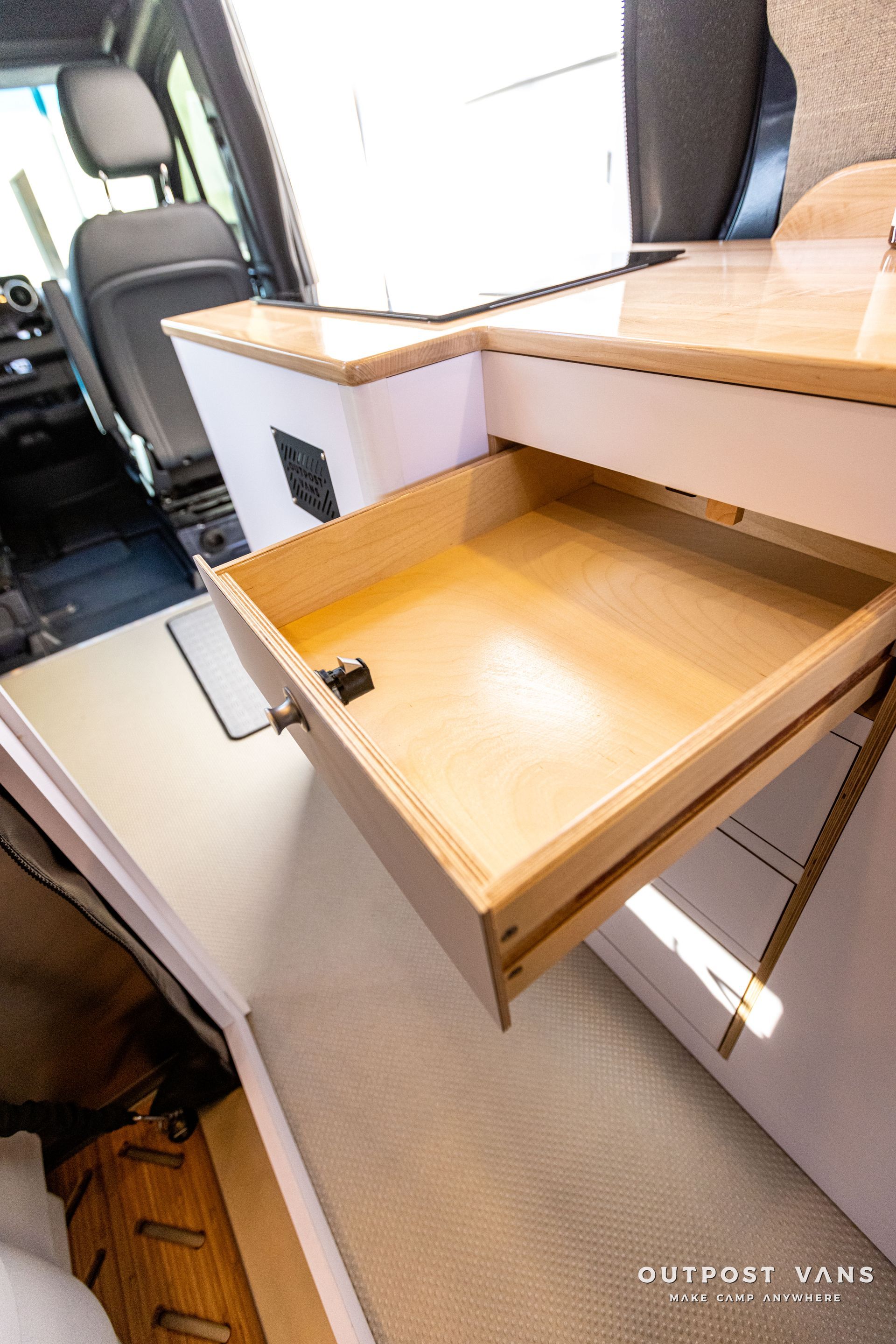 a wooden drawer is open in a camper van .