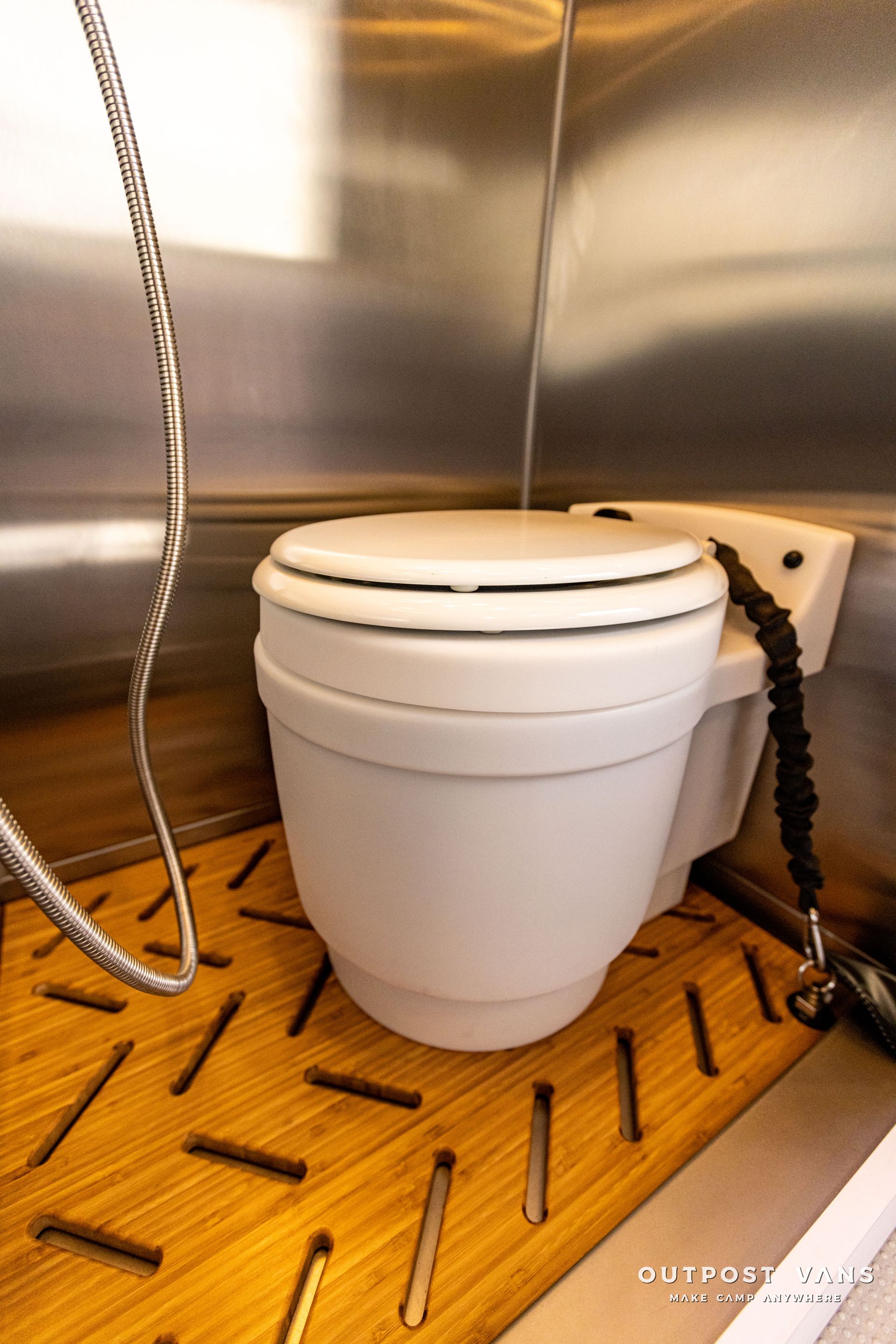 a white toilet with a hose attached to it
