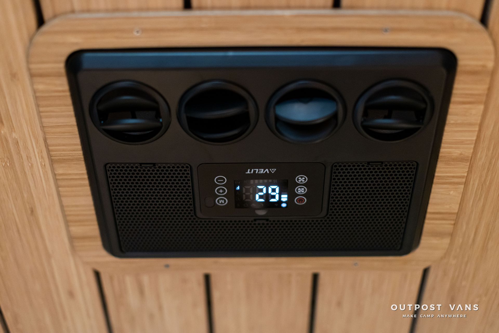 Black car rear console with four air vents and a digital climate control display showing 29°