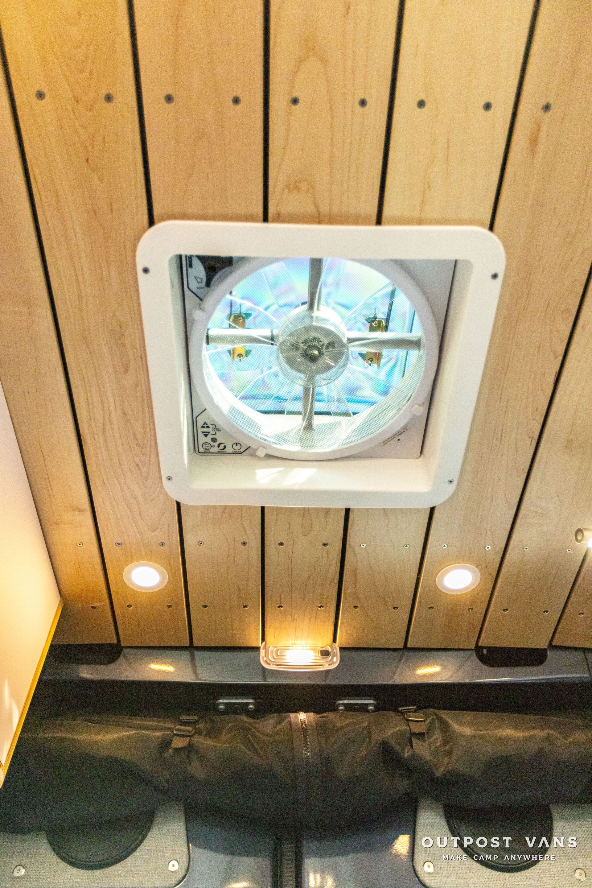 a fan is hanging from the ceiling of a wooden room .