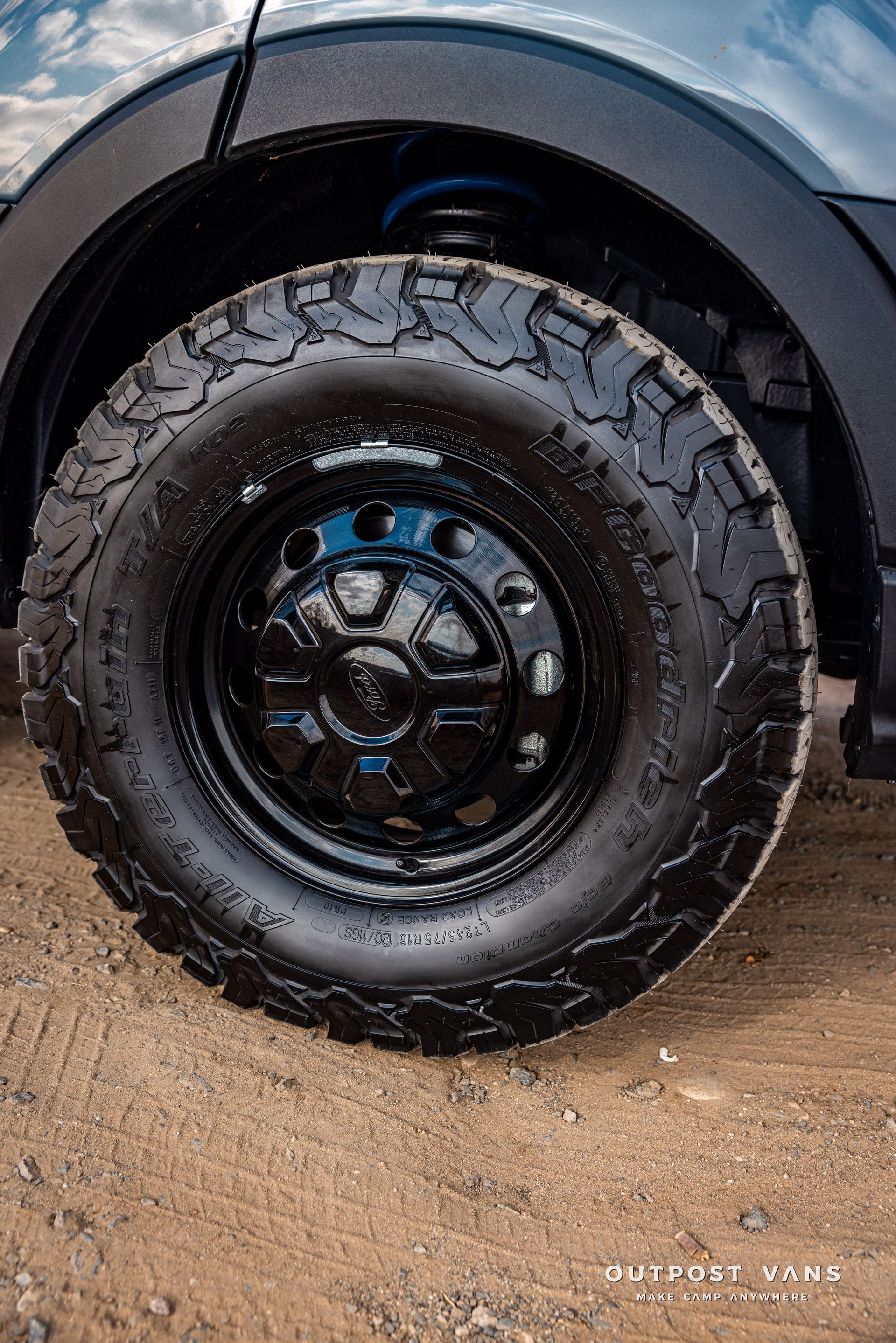 a close up of a truck tire on a dirt road .