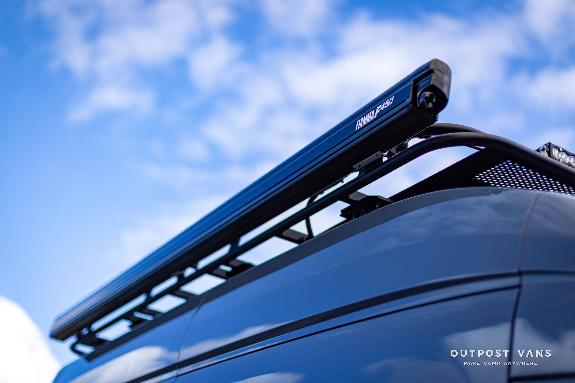 a blue awning is attached to the roof of a van .
