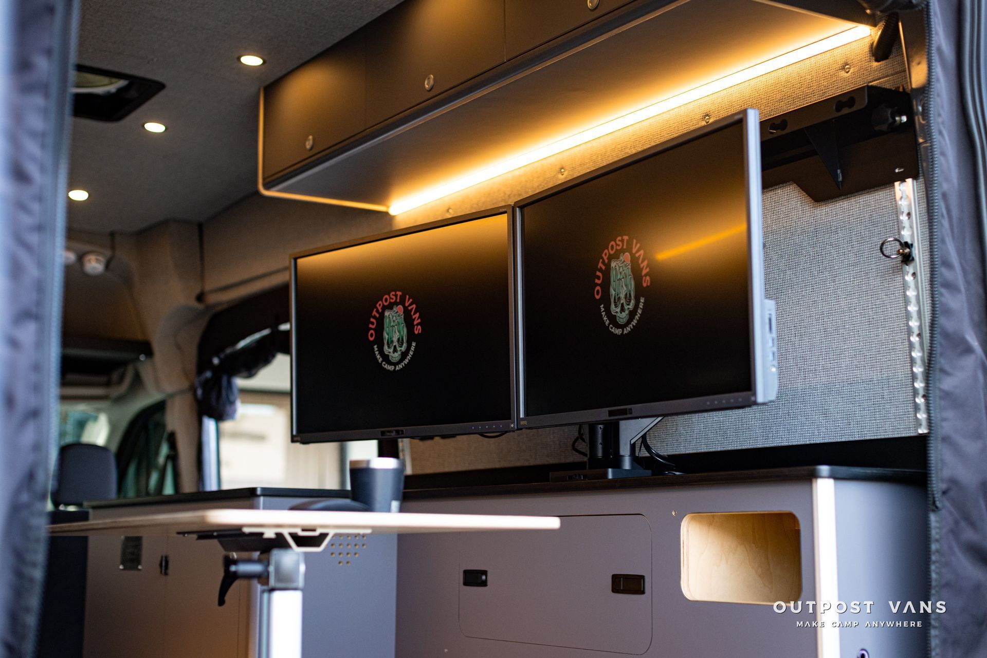 a van with two monitors and a table in the back .