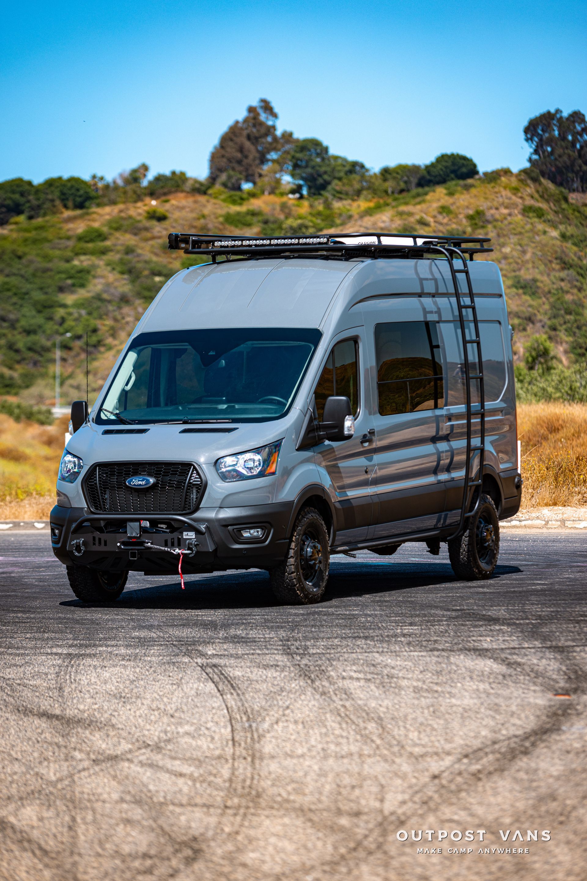 a ford transit van is parked on the side of the road .