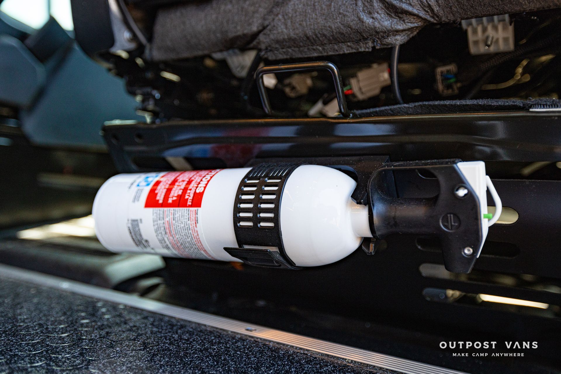 a fire extinguisher is attached to the back of a car seat .