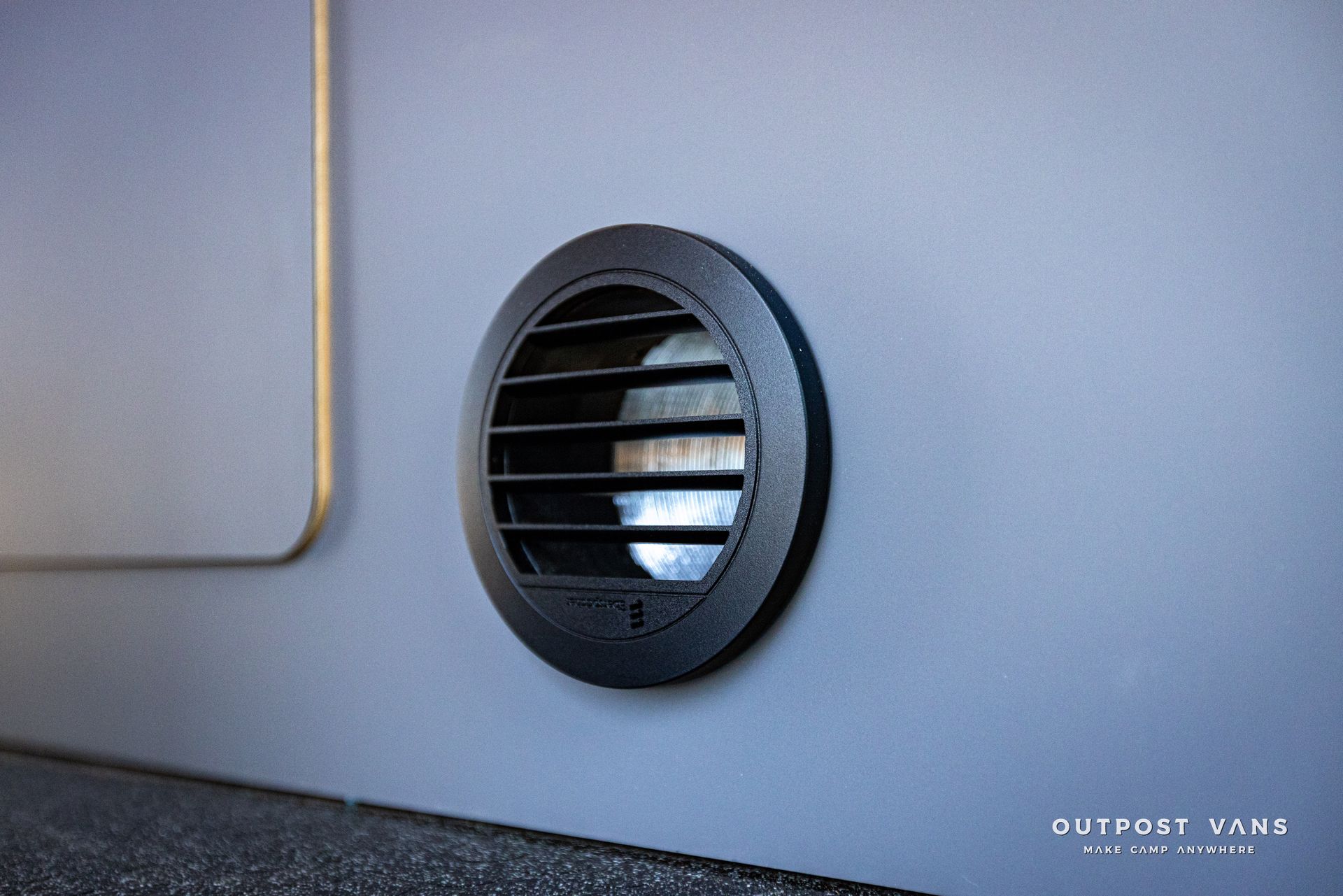 a close up of a round vent on a wall .