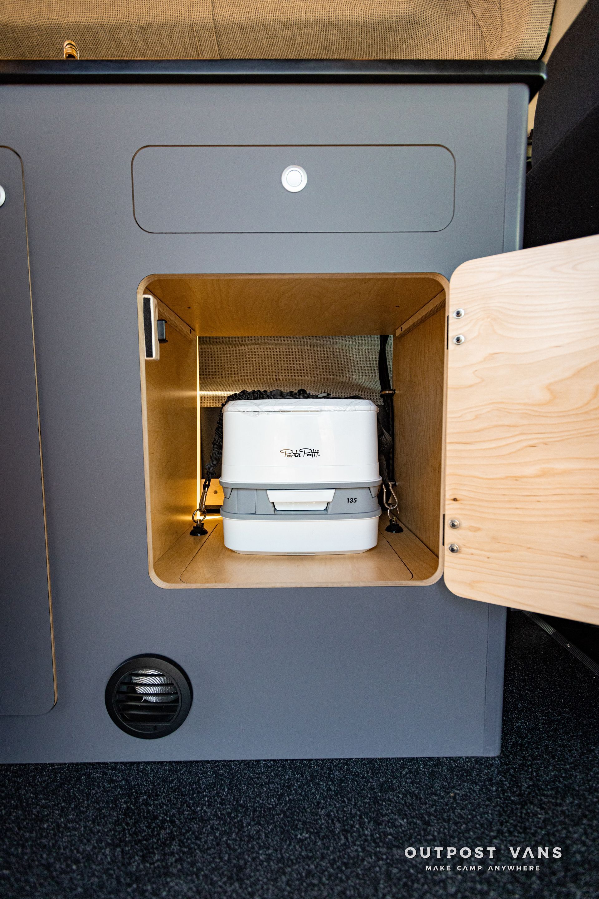 a porta potty is sitting inside of a cabinet with the door open .