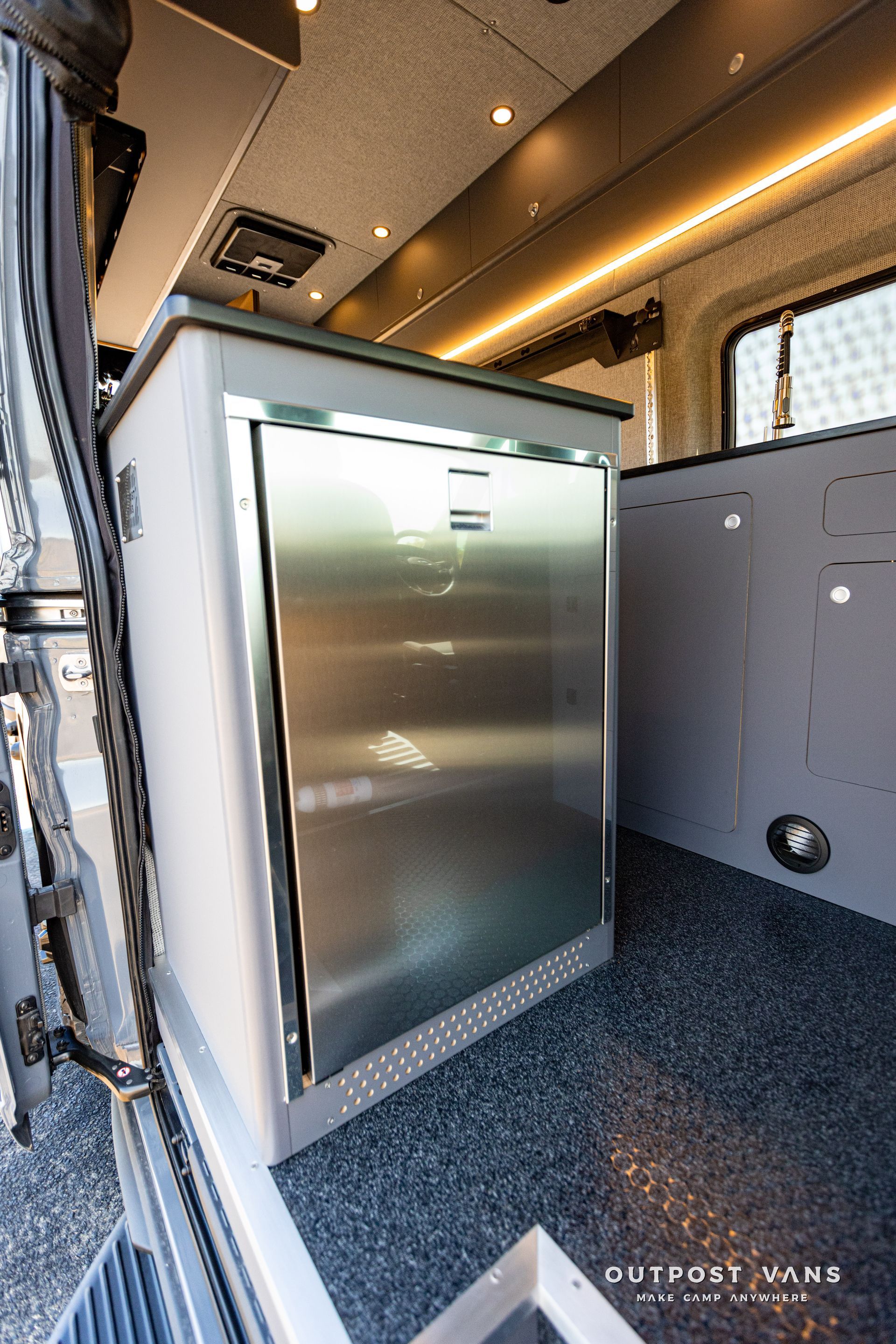 a stainless steel refrigerator is in the back of a van .