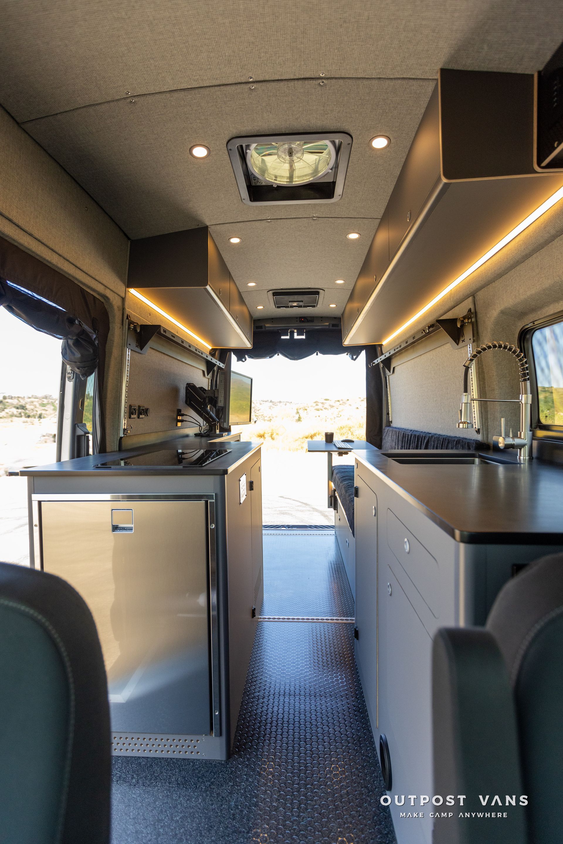 the inside of a van with a kitchen and sink .