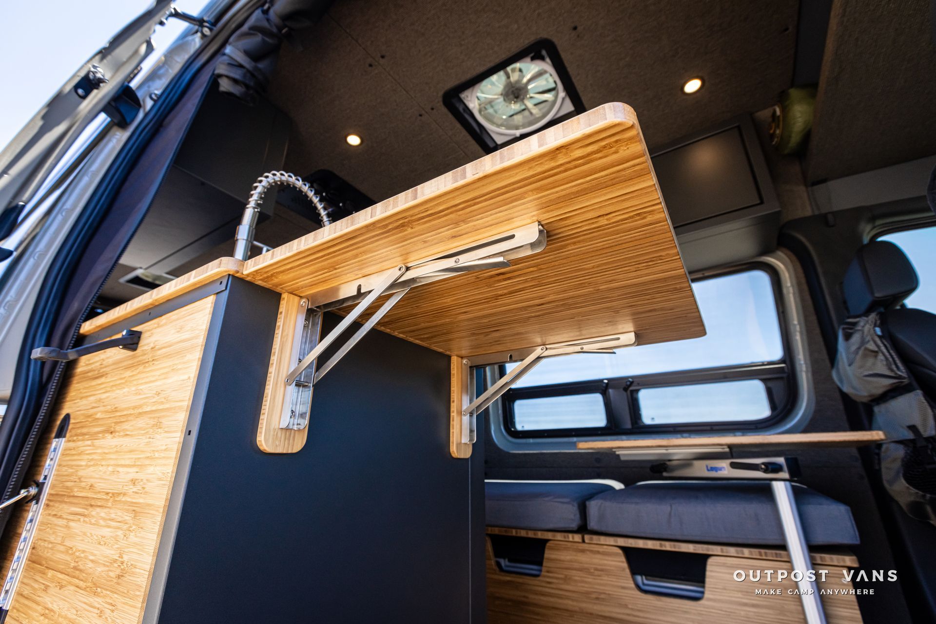 A wooden table is folded up in the back of a van.