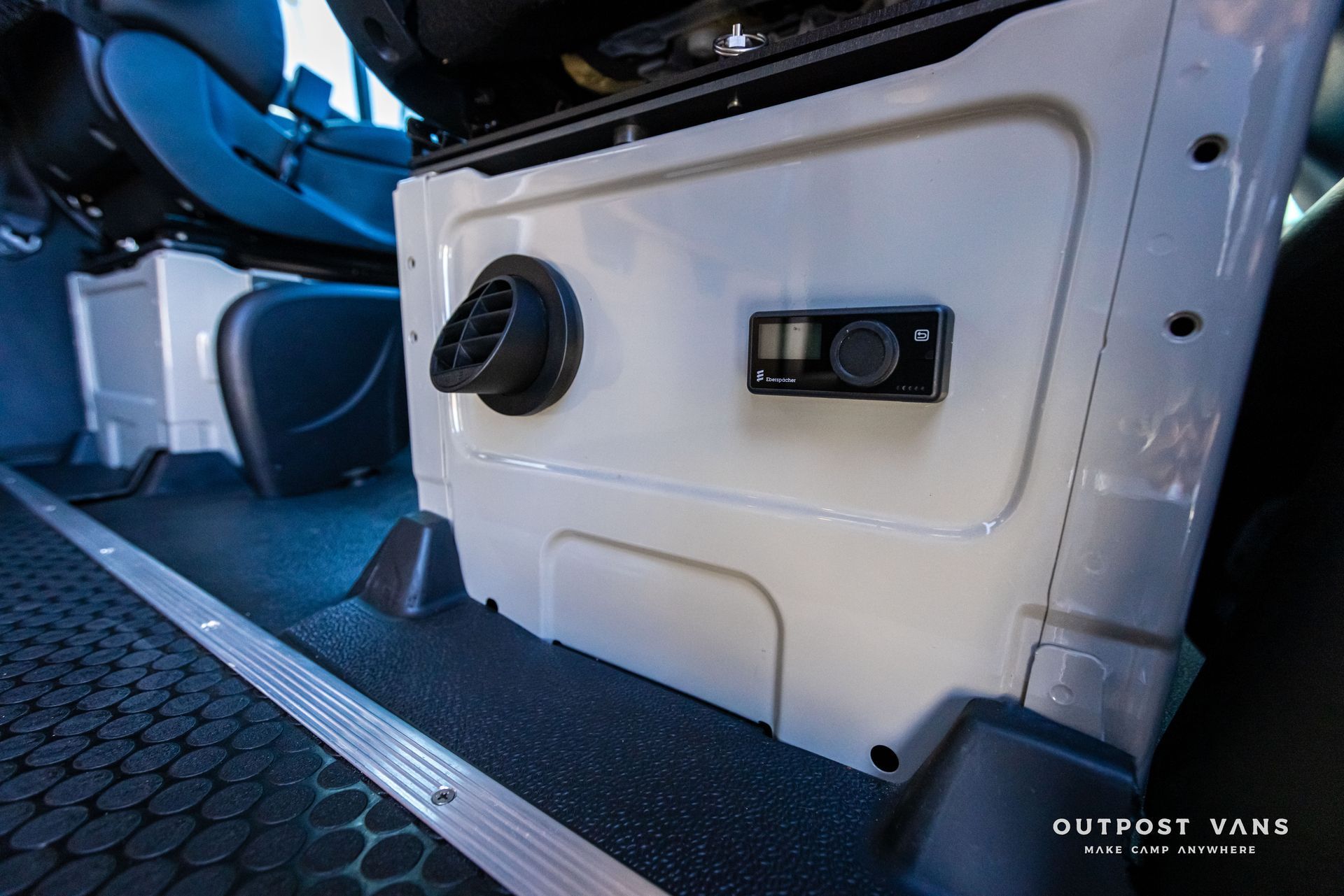 A white box is sitting under a seat in a car.