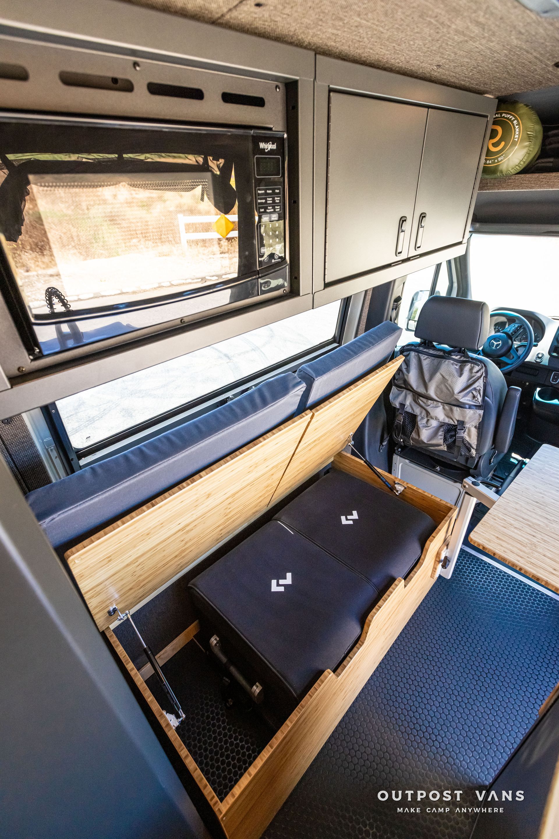 A van with a bed and a drawer underneath it.