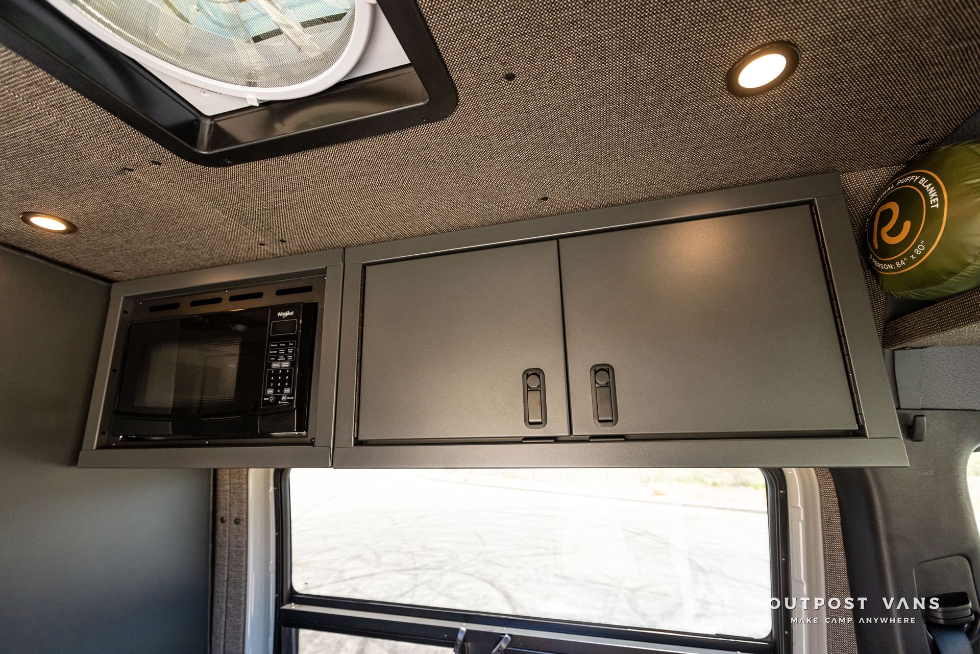 A van with a microwave and cabinets on the ceiling.