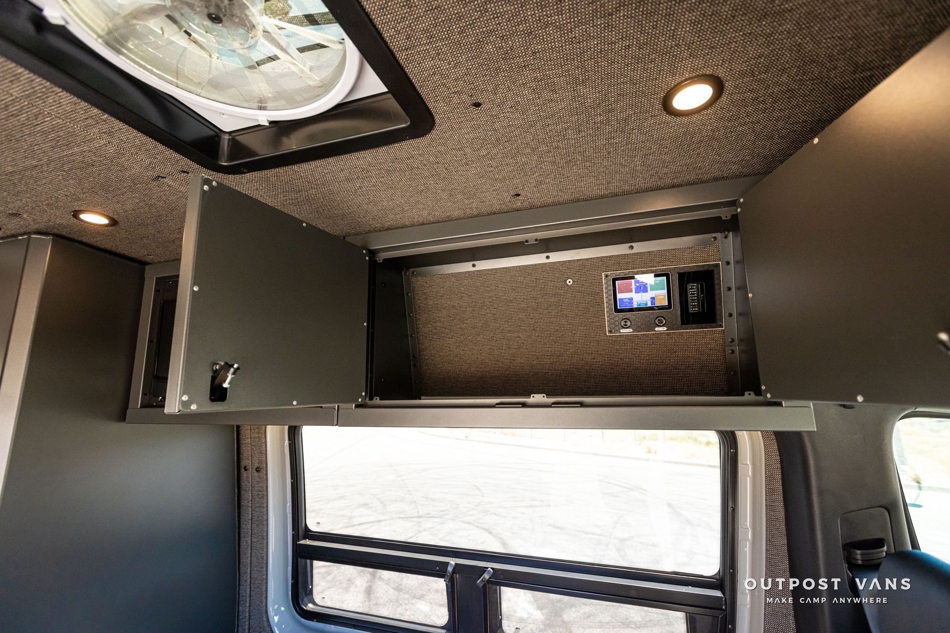 A van with a ceiling fan and a tv mounted to the ceiling.