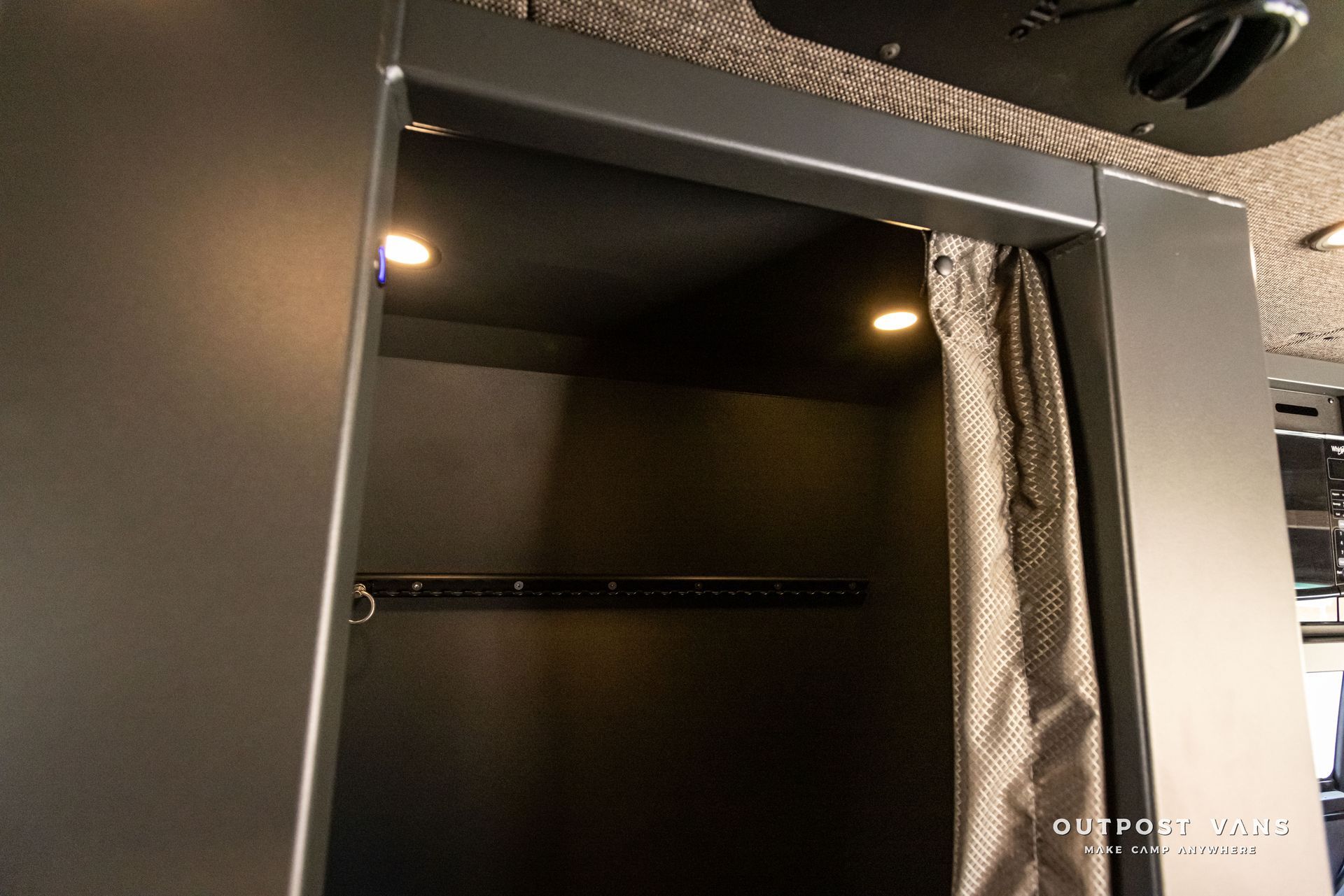 A black closet with a brown curtain and lights