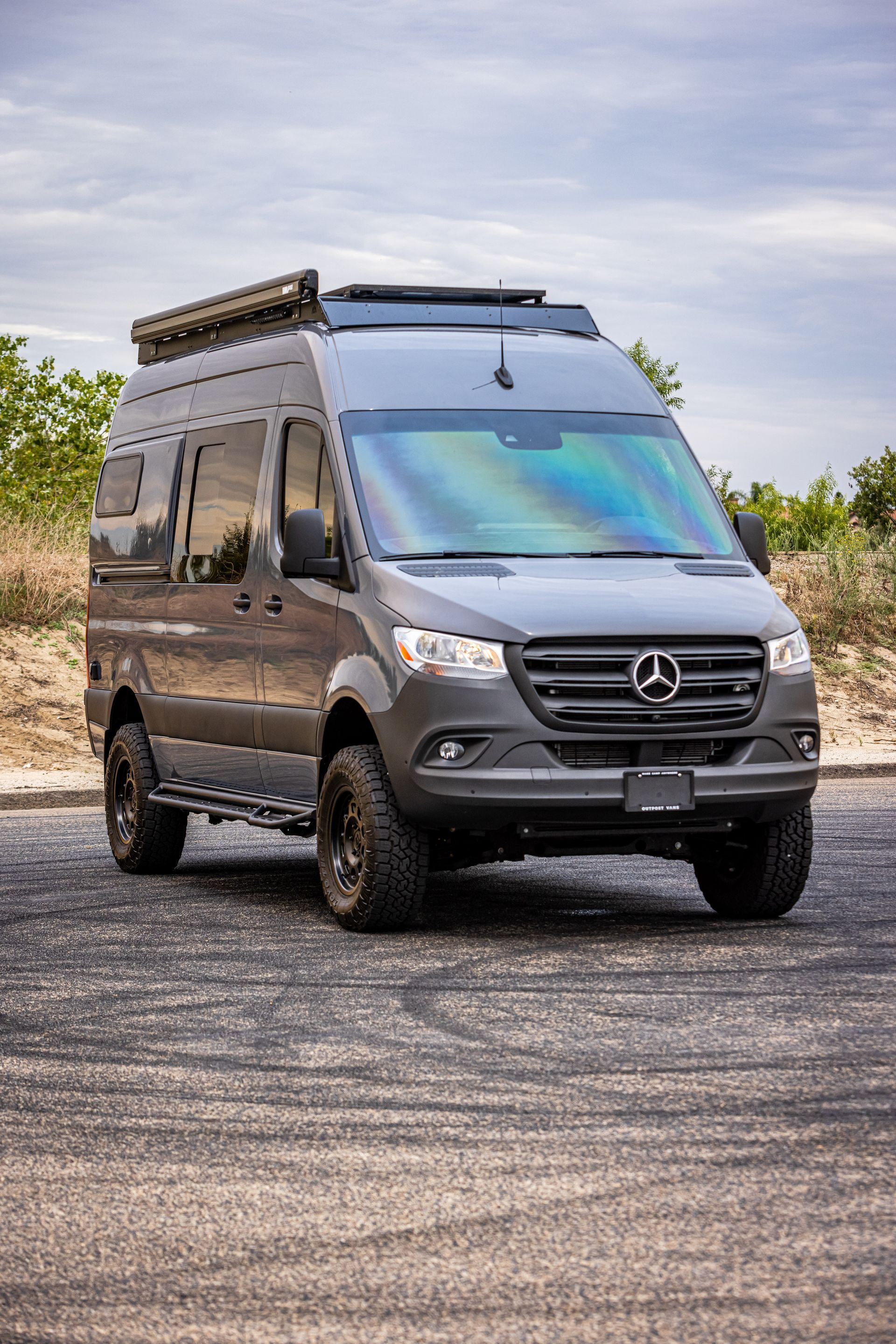 A mercedes sprinter van is parked on the side of the road.