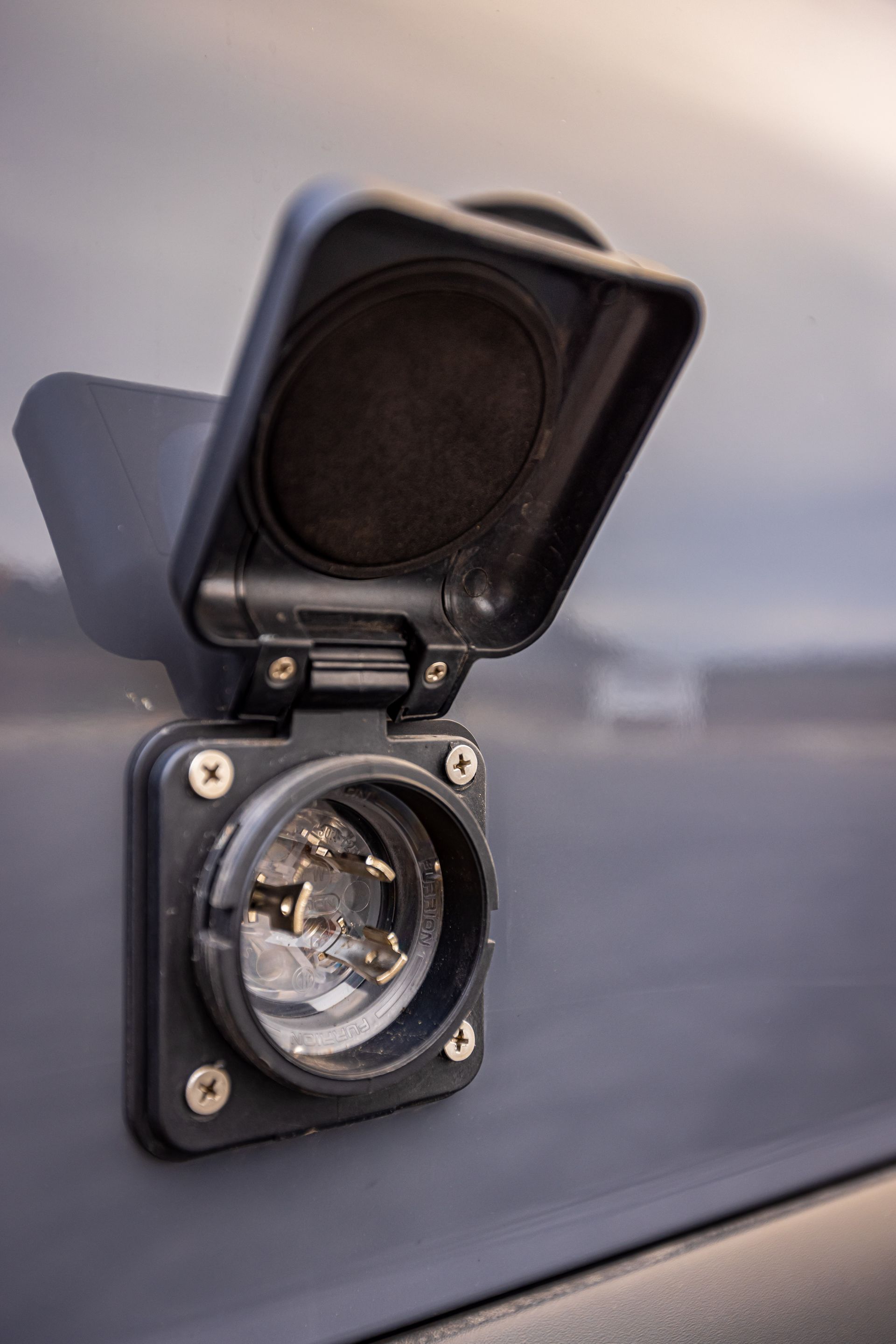 A close up of a power outlet on the side of a car.