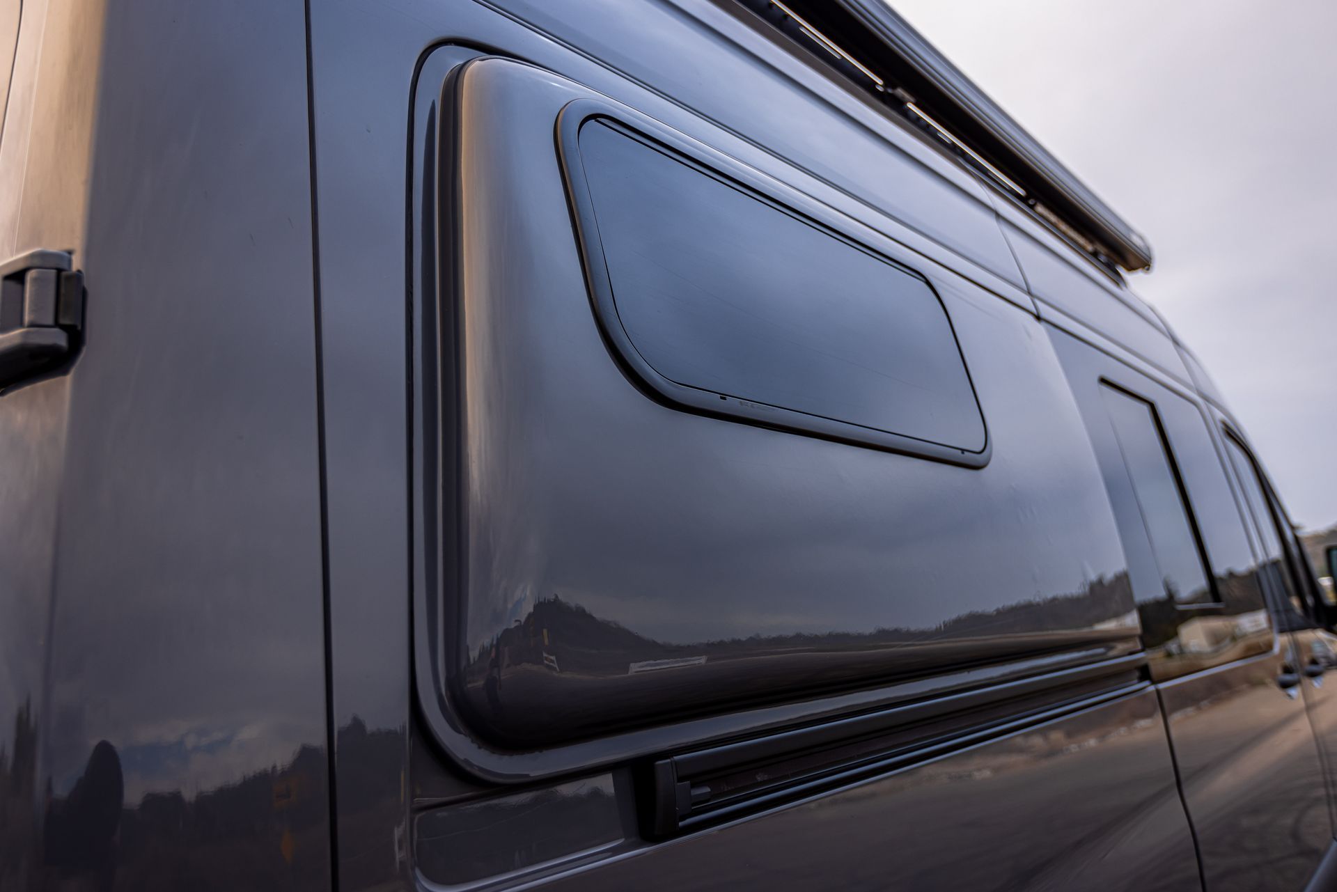 A black van with a large window on the side of it.