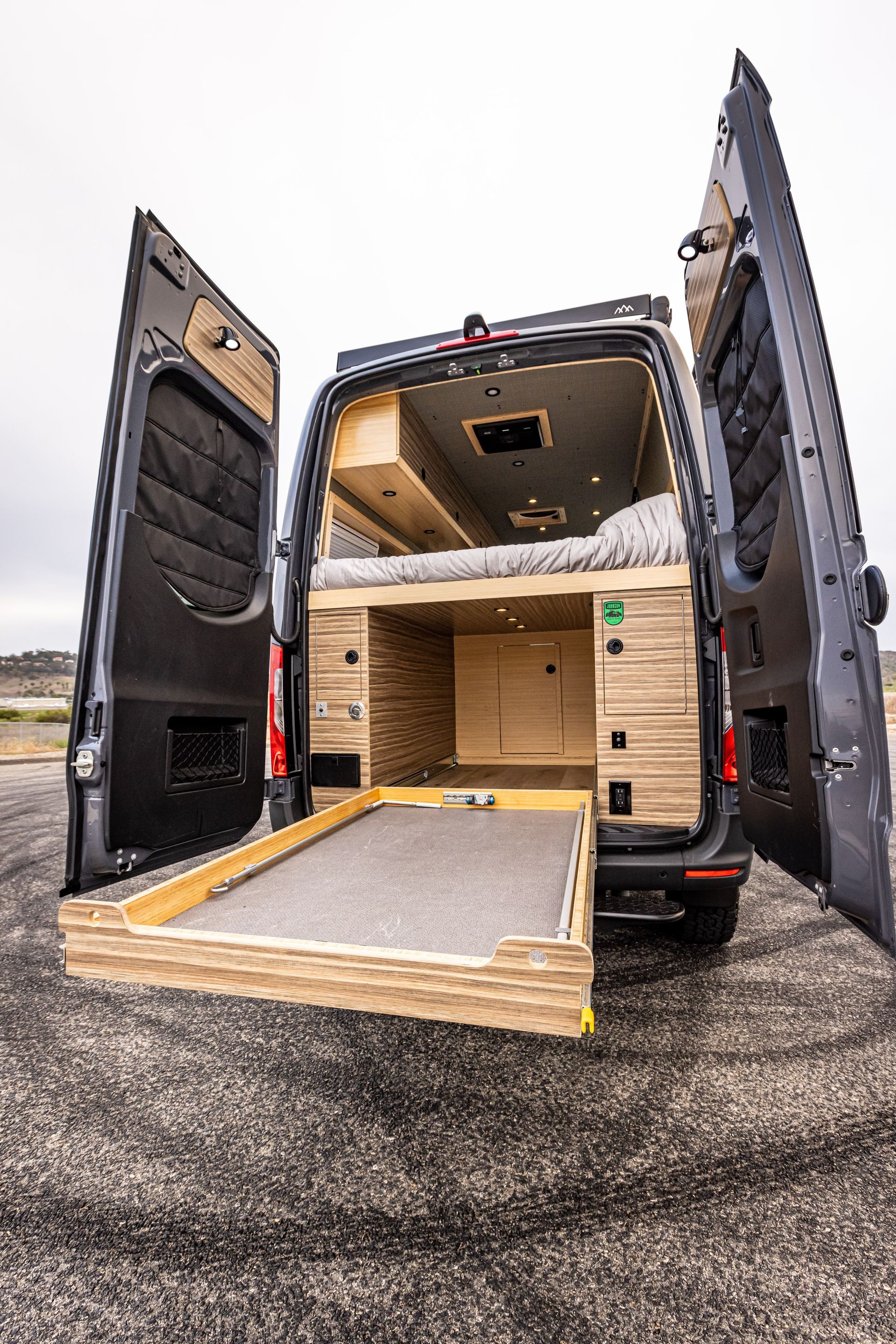 The back of a van with its doors open and a ramp.