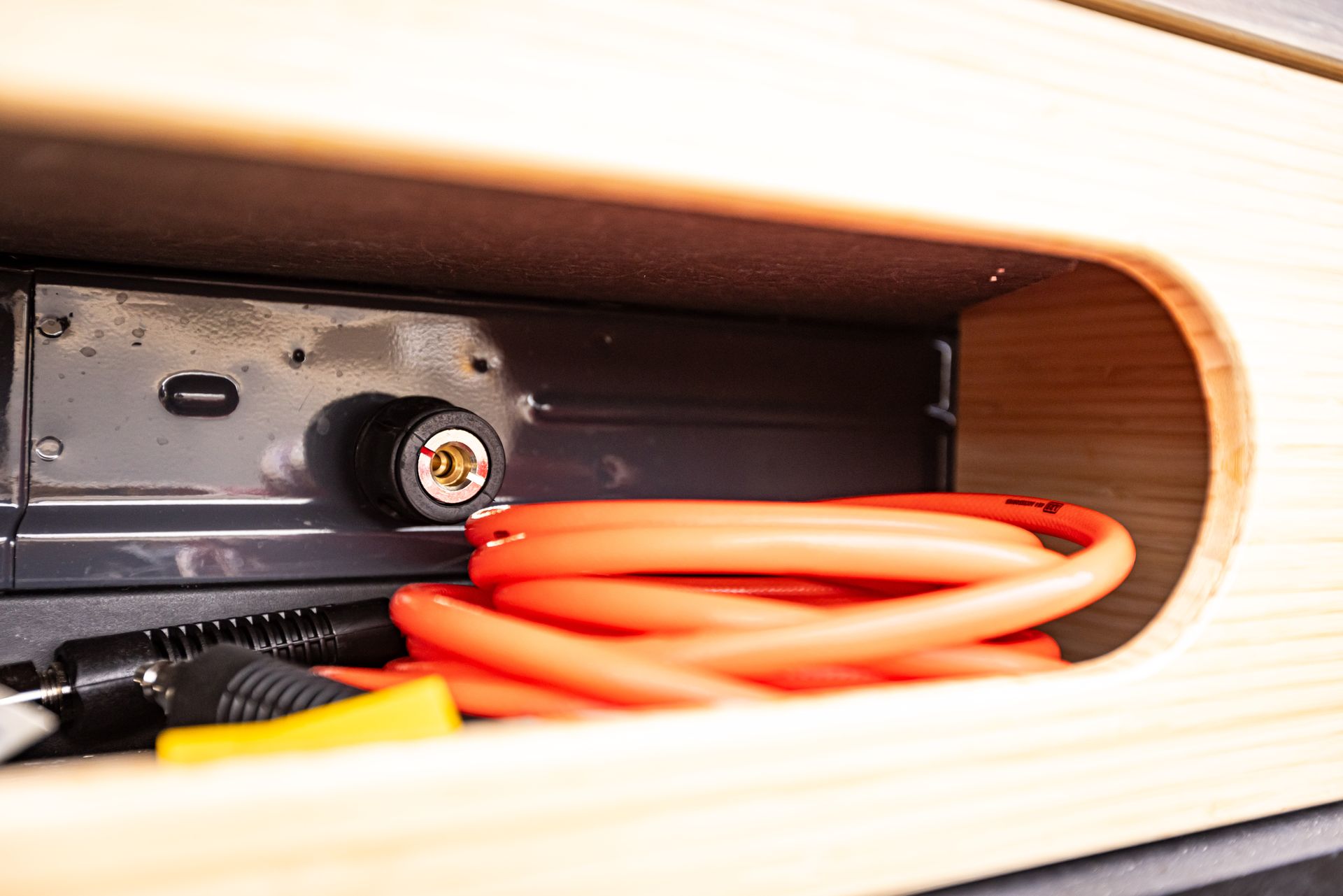 A close up of a power cord in a shelf.