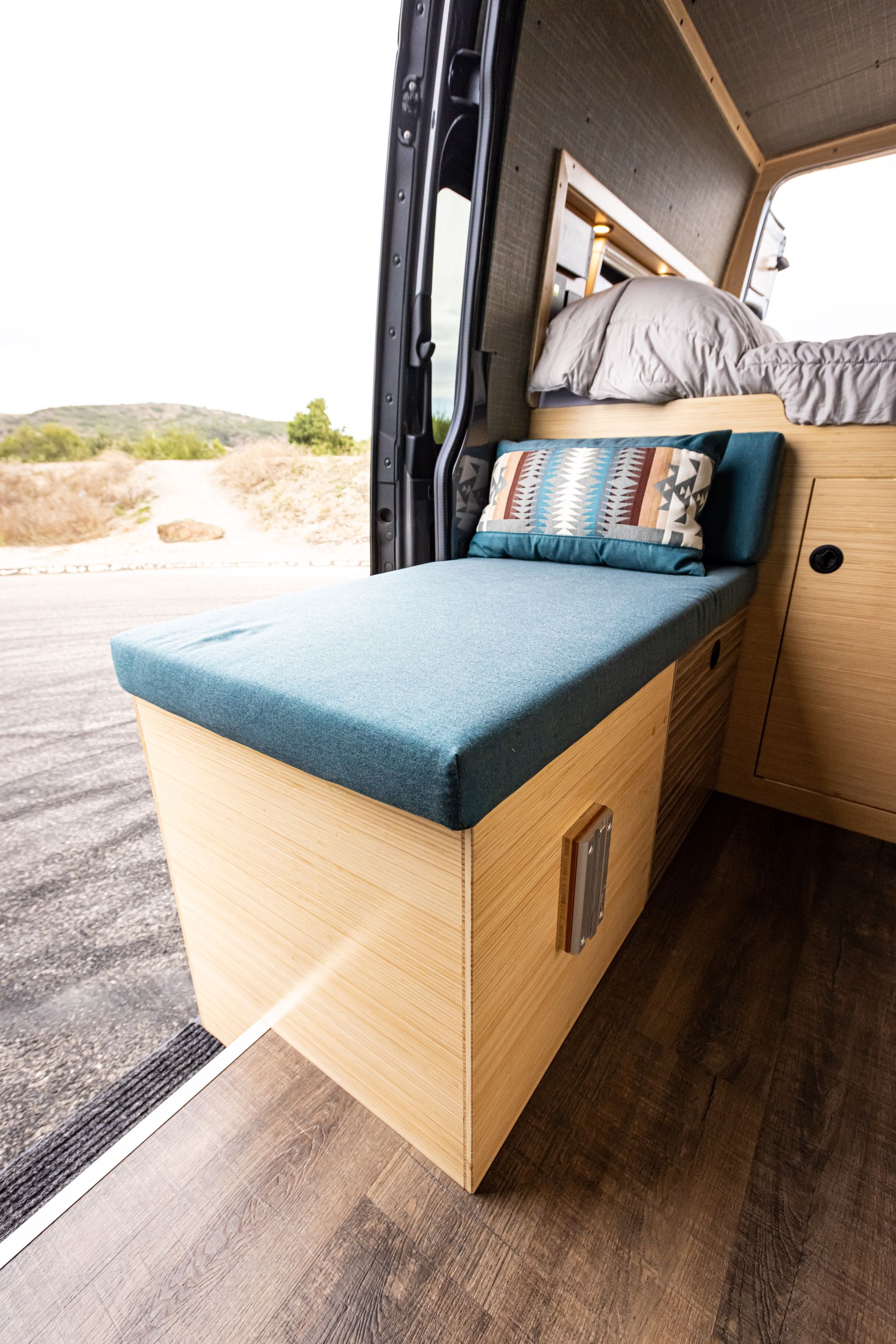 There is a bed in the back of a van.