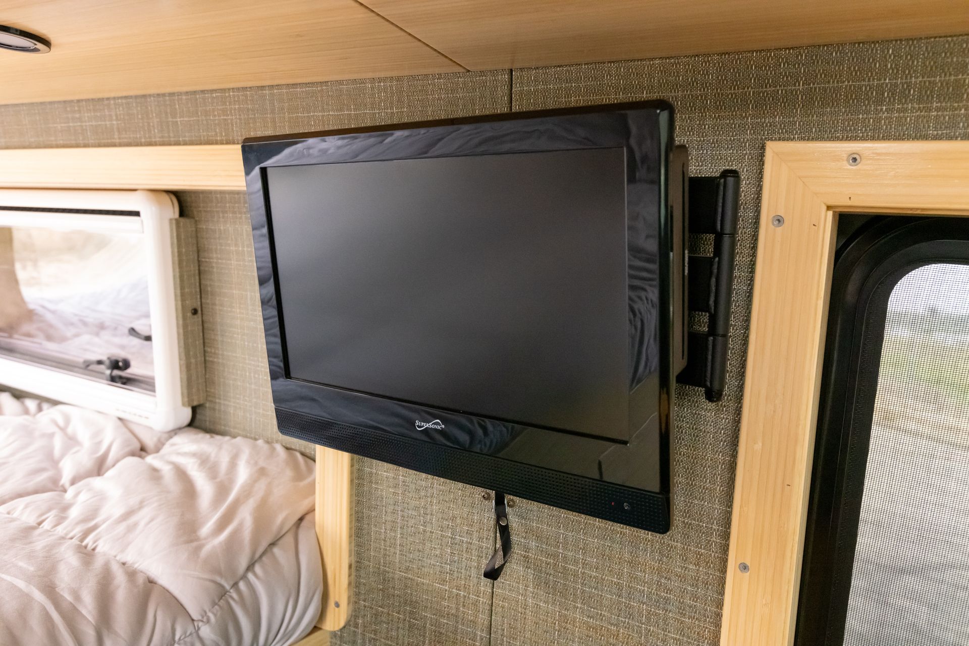 A flat screen tv is mounted to the wall in a camper.