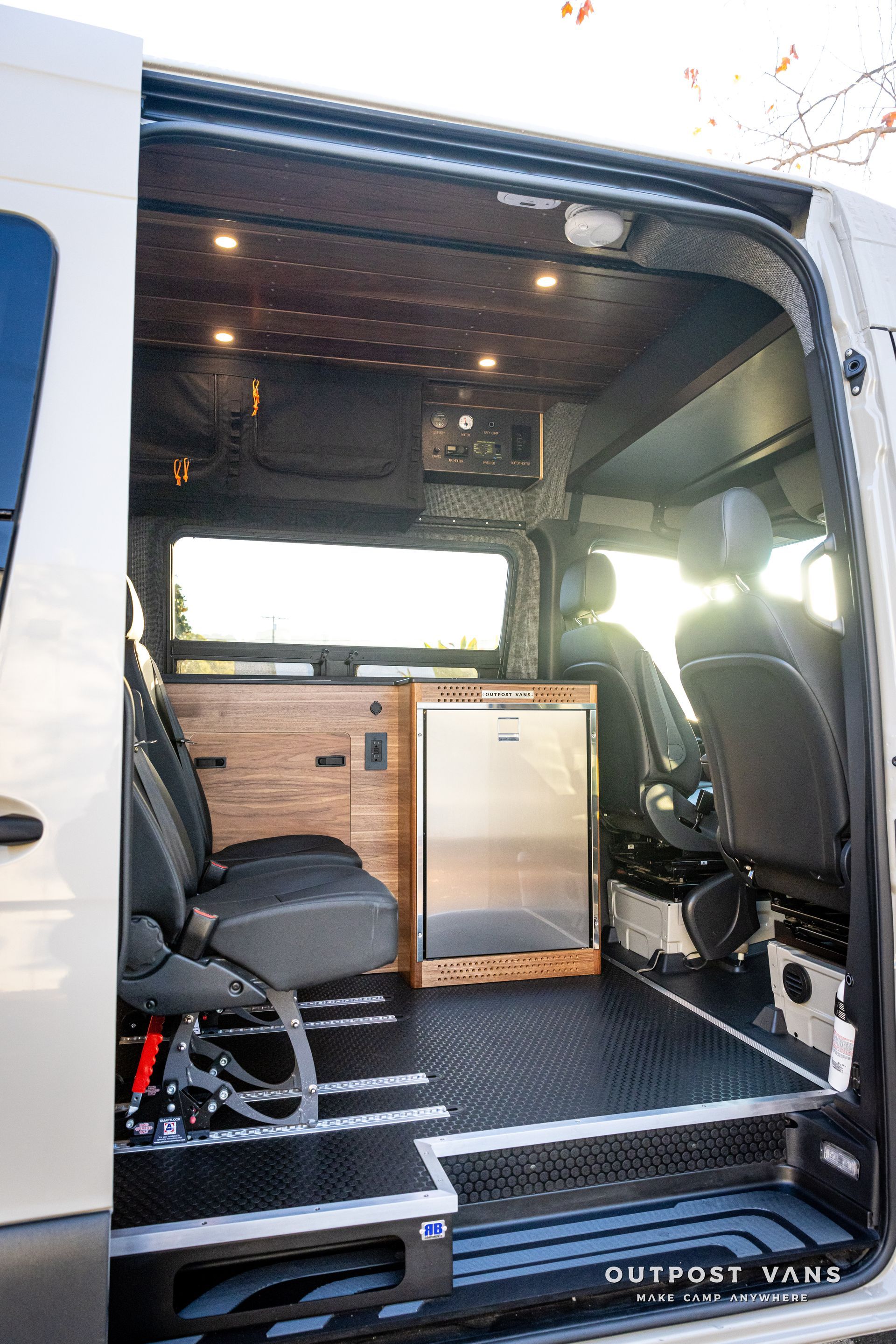the inside of a van with the door open and a refrigerator .