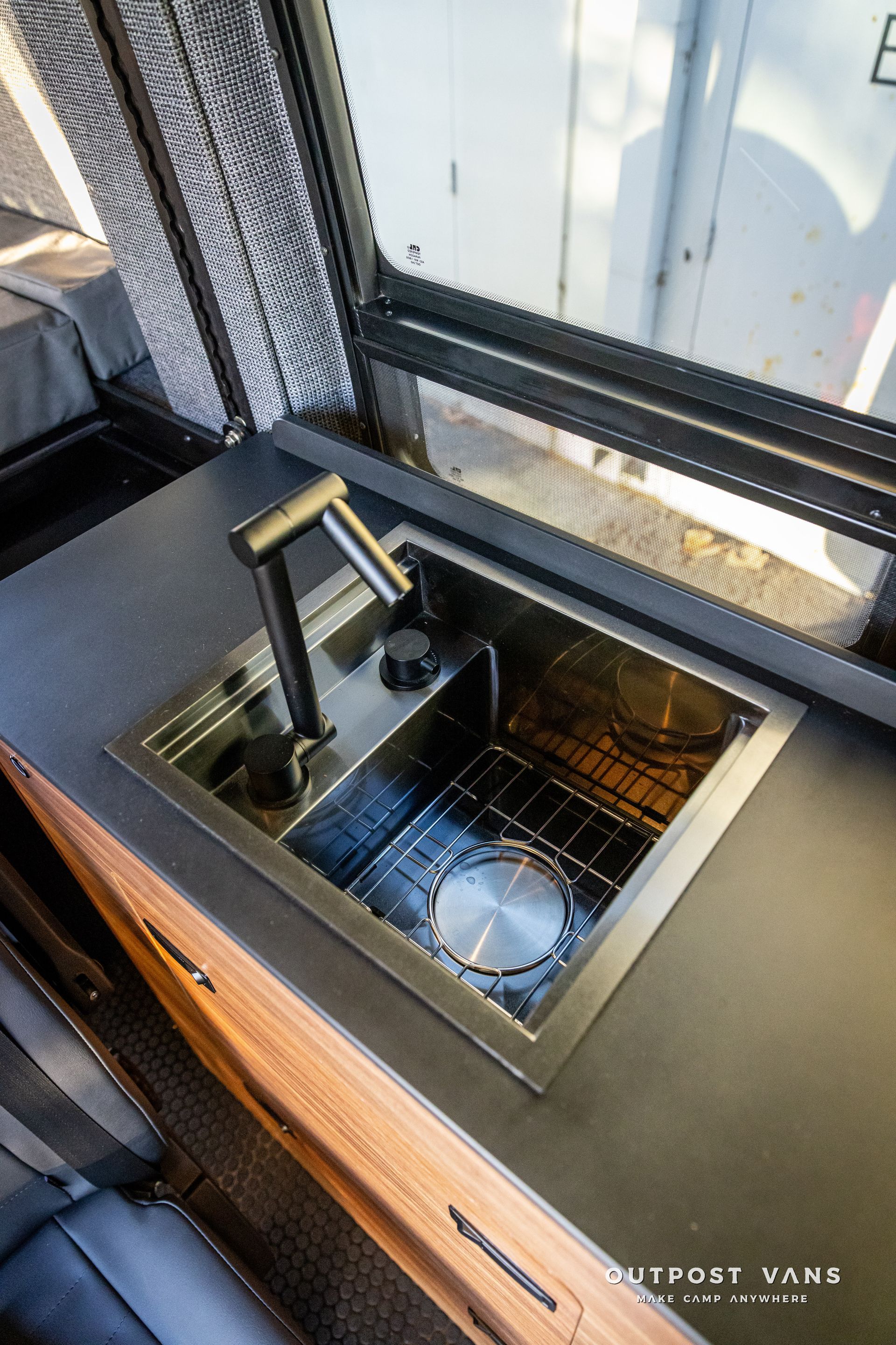 a kitchen sink with a faucet and a window in a van .