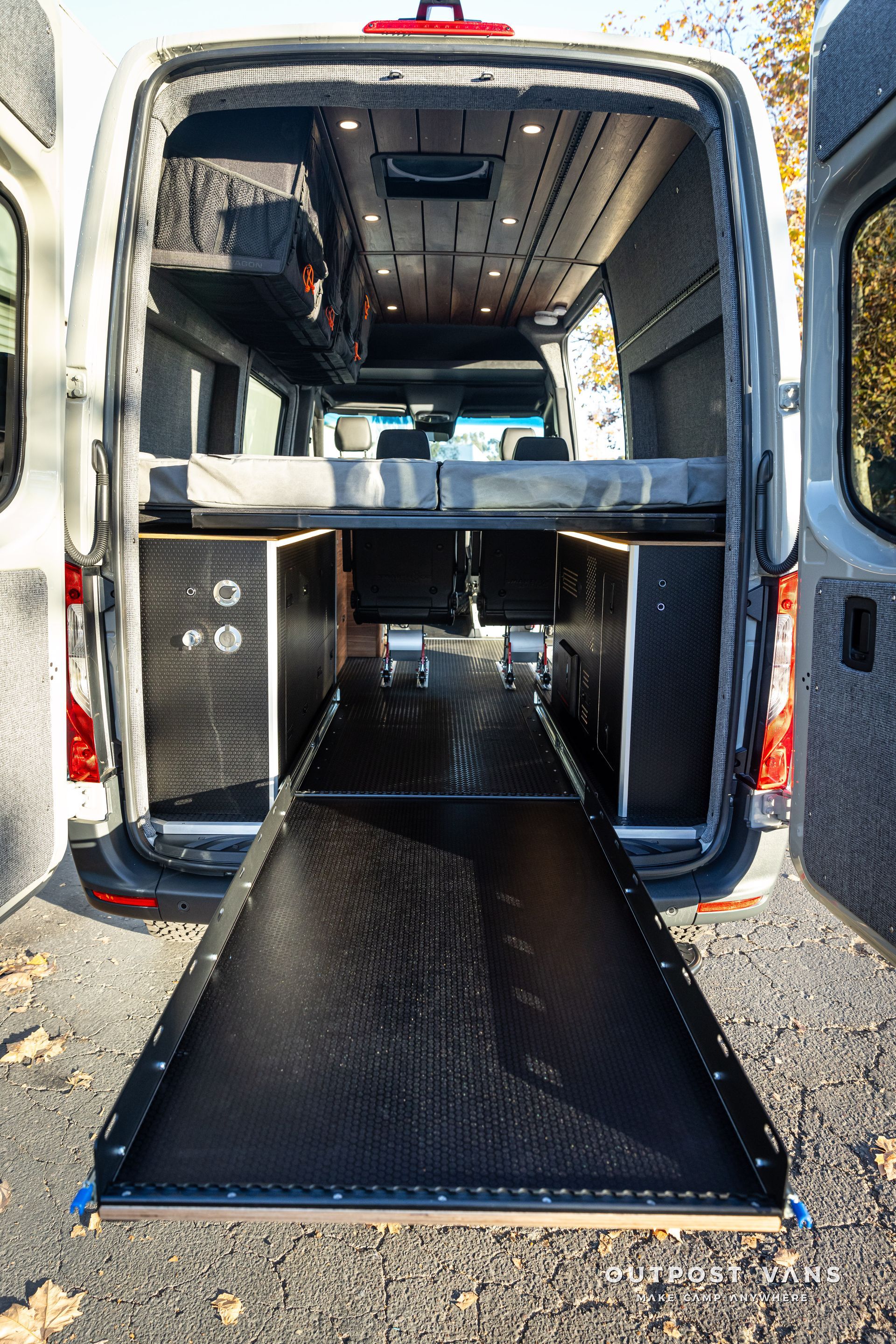 the back of a van with the door open and a ramp .