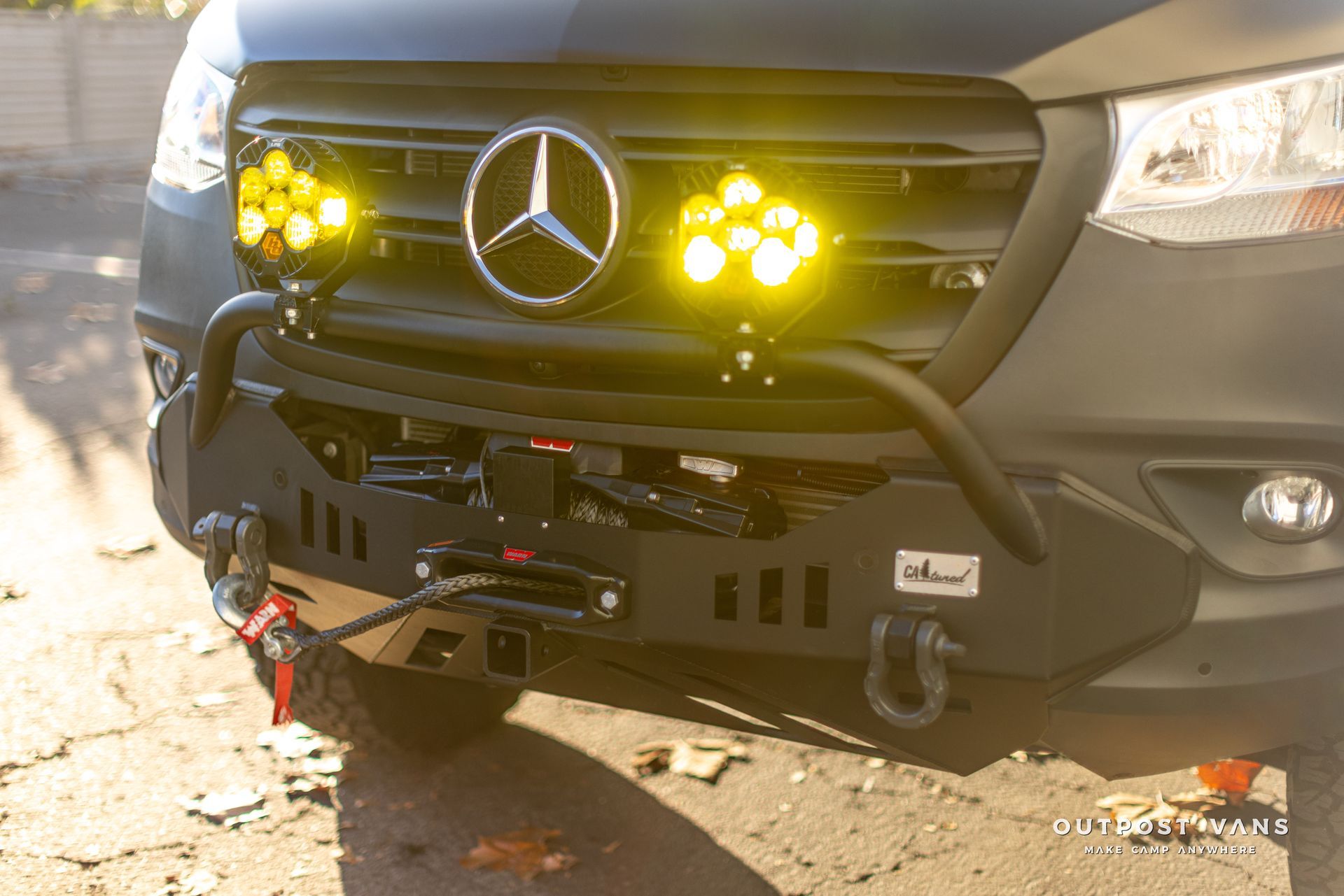 the front of a mercedes sprinter van with yellow lights on it .