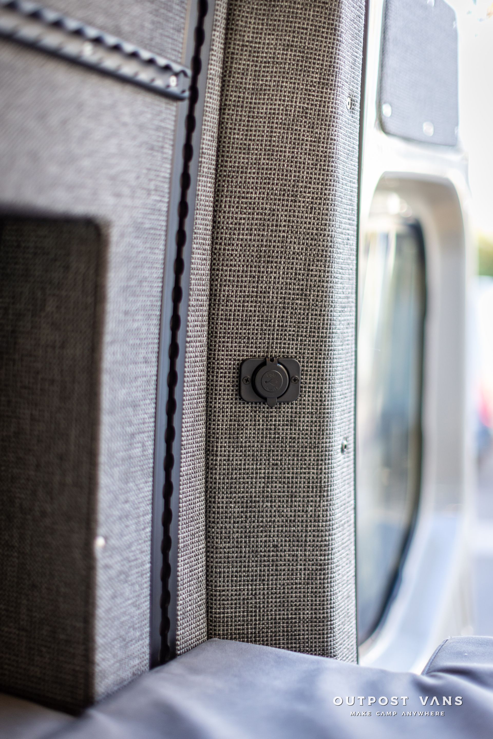 a close up of a gray wall with a black button on it .
