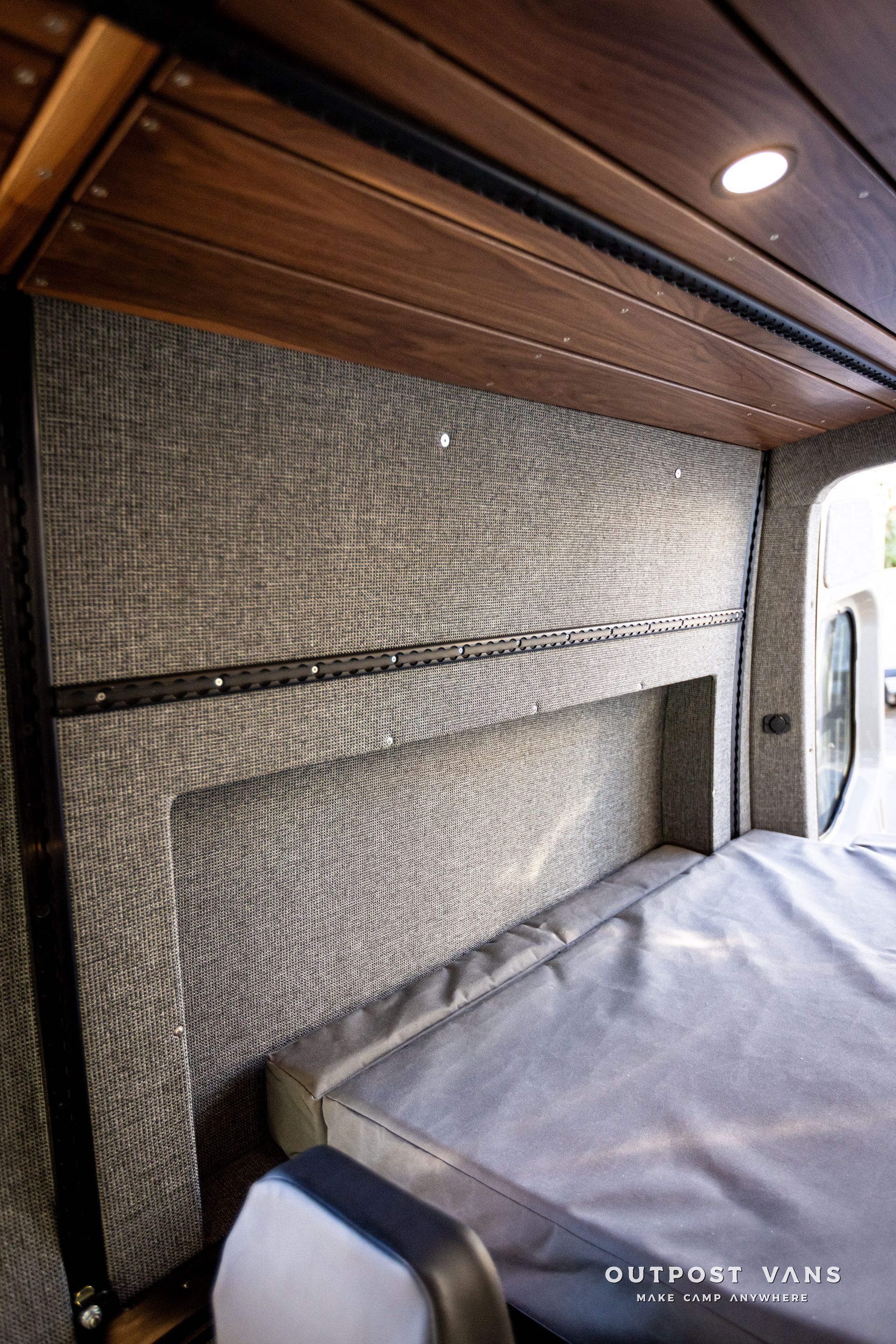 there is a bed in the back of a van .