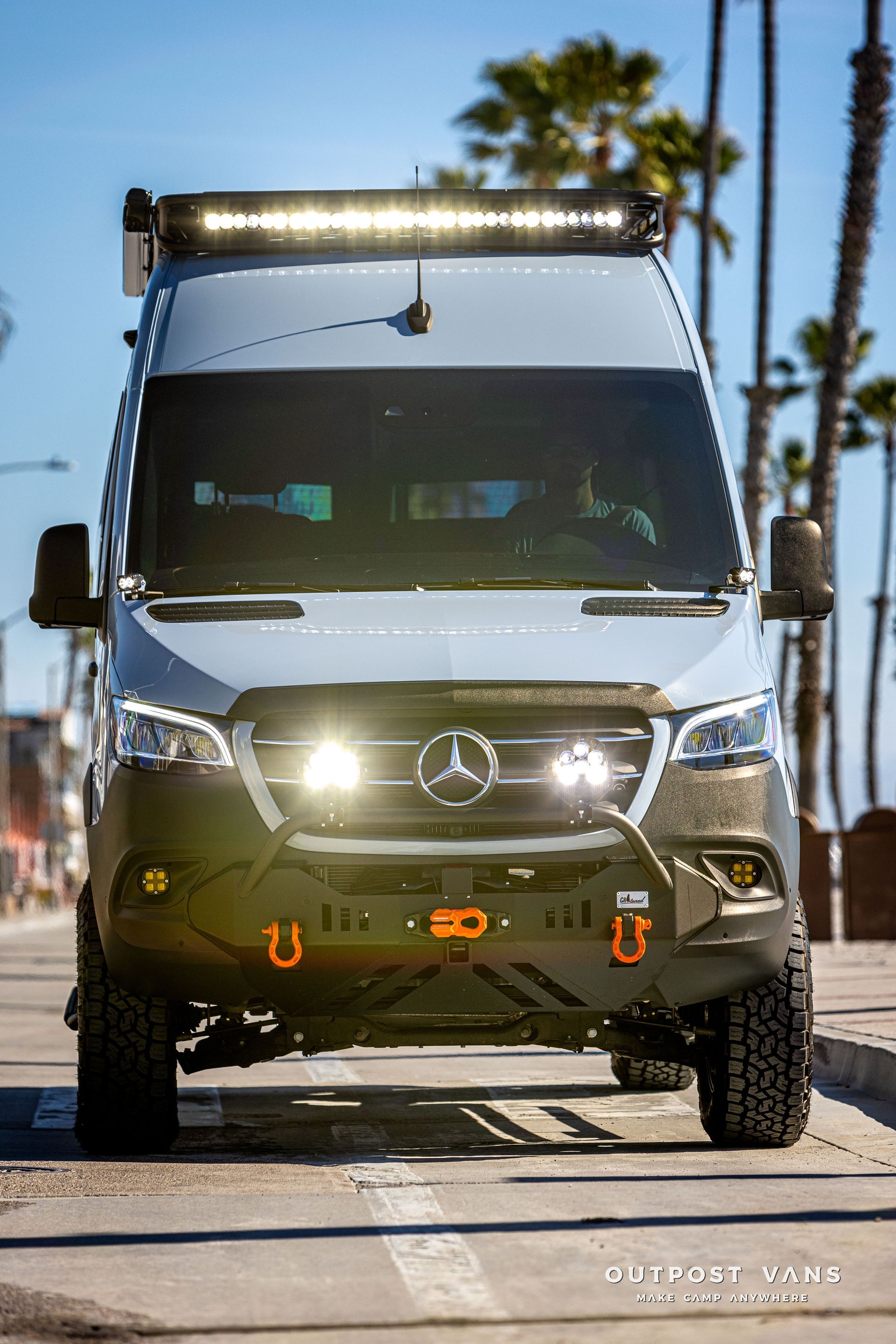 a mercedes sprinter van is parked on the side of the road .