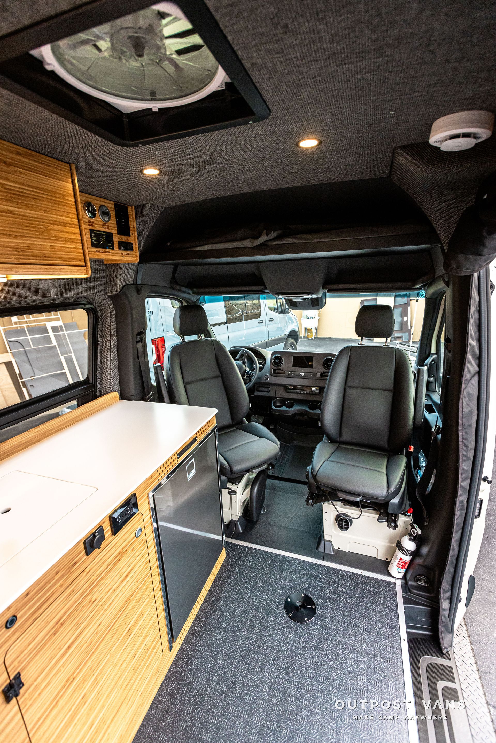 The inside of a camper van with two seats and a table.