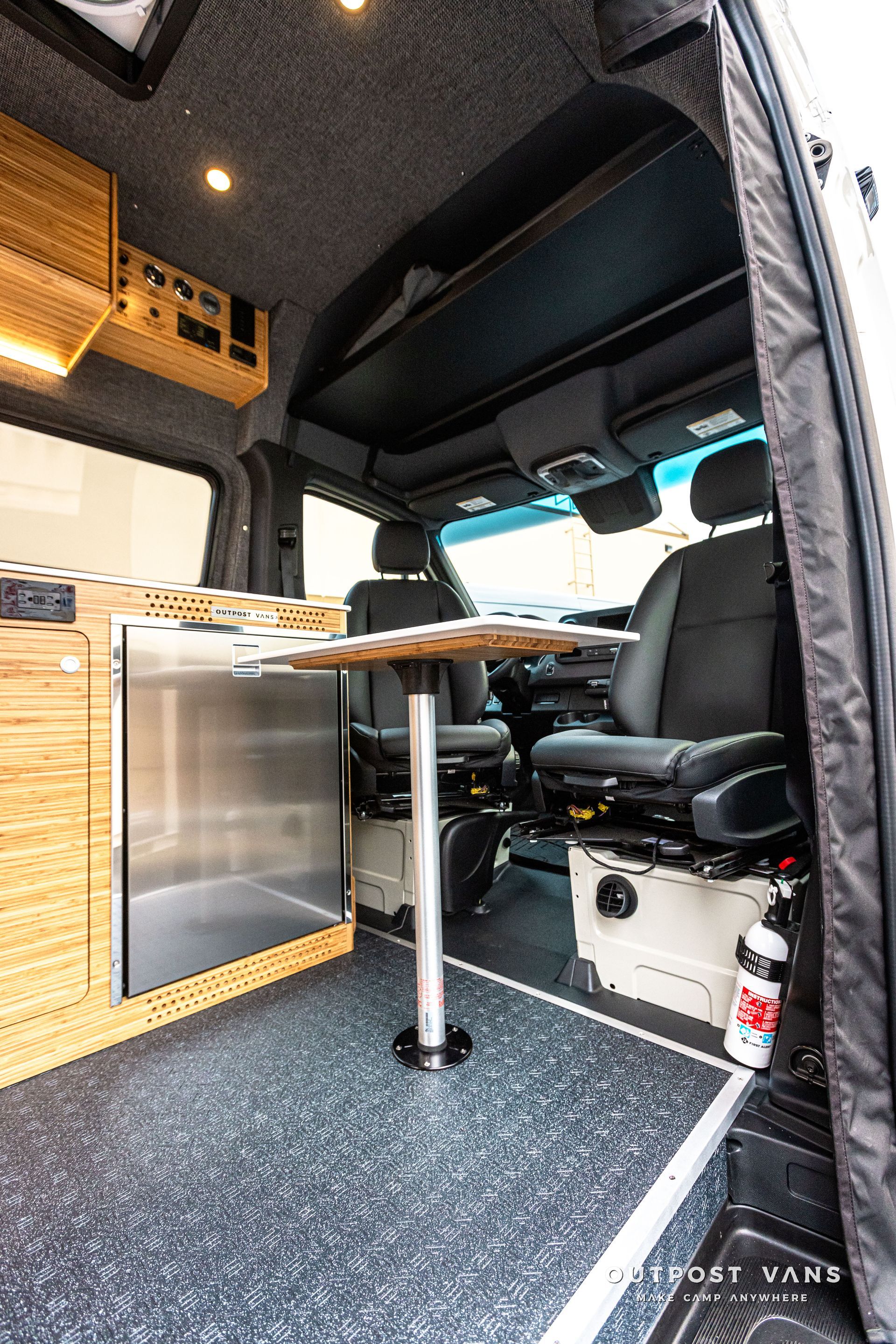 The inside of a van with a table and chairs.