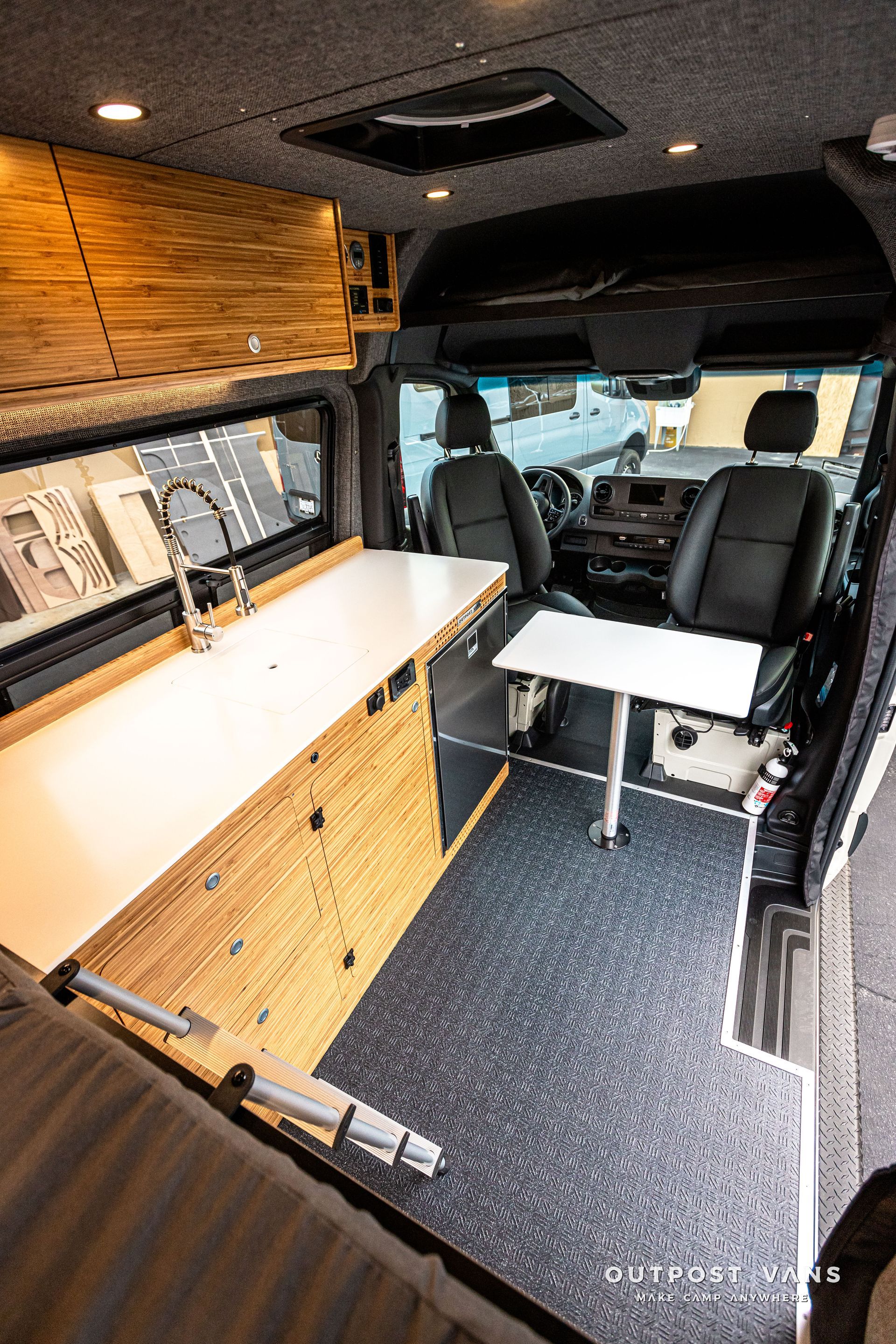 The inside of a van with a table and a sink.