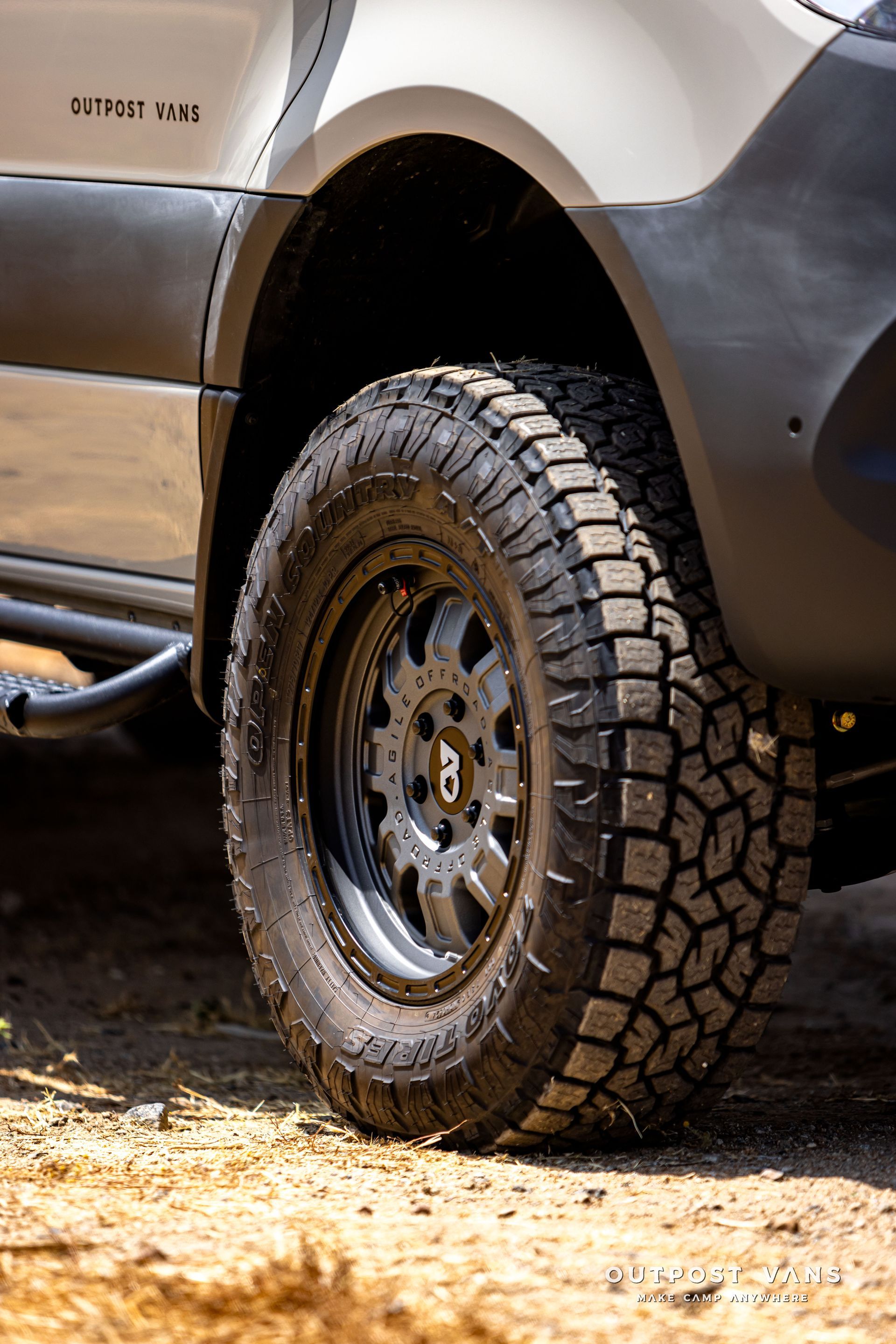 A close up of a truck tire on a dirt road.