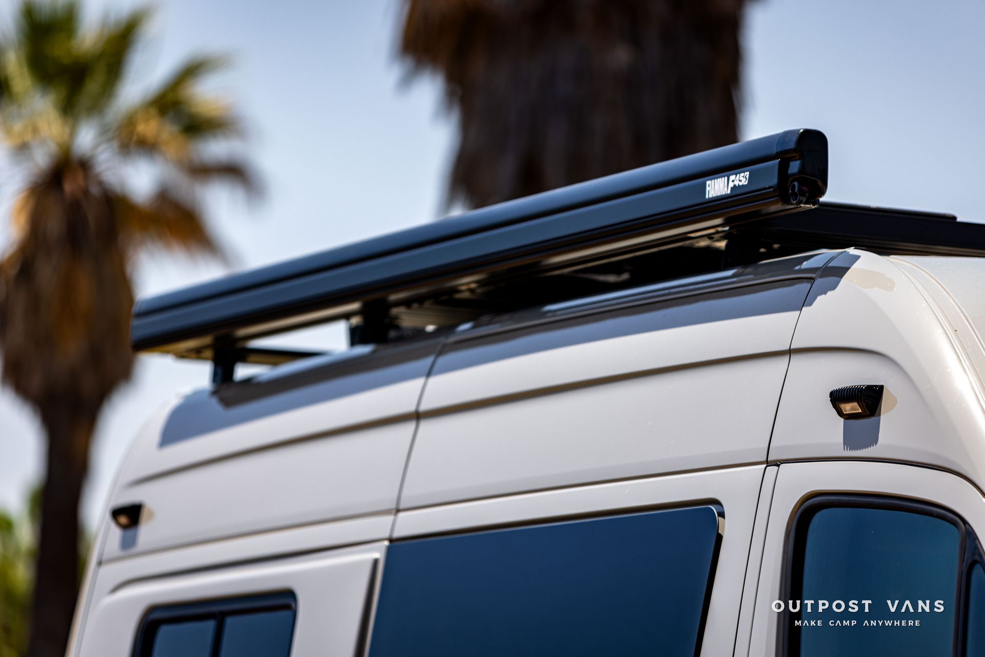 A white van with a black awning on top of it.
