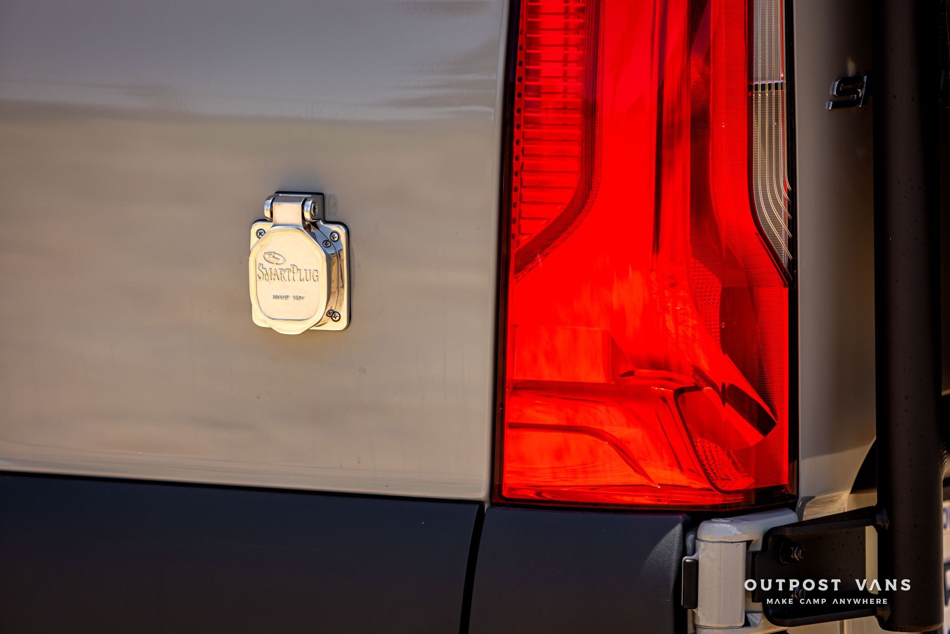A close up of a car 's tail light with a plug in it.