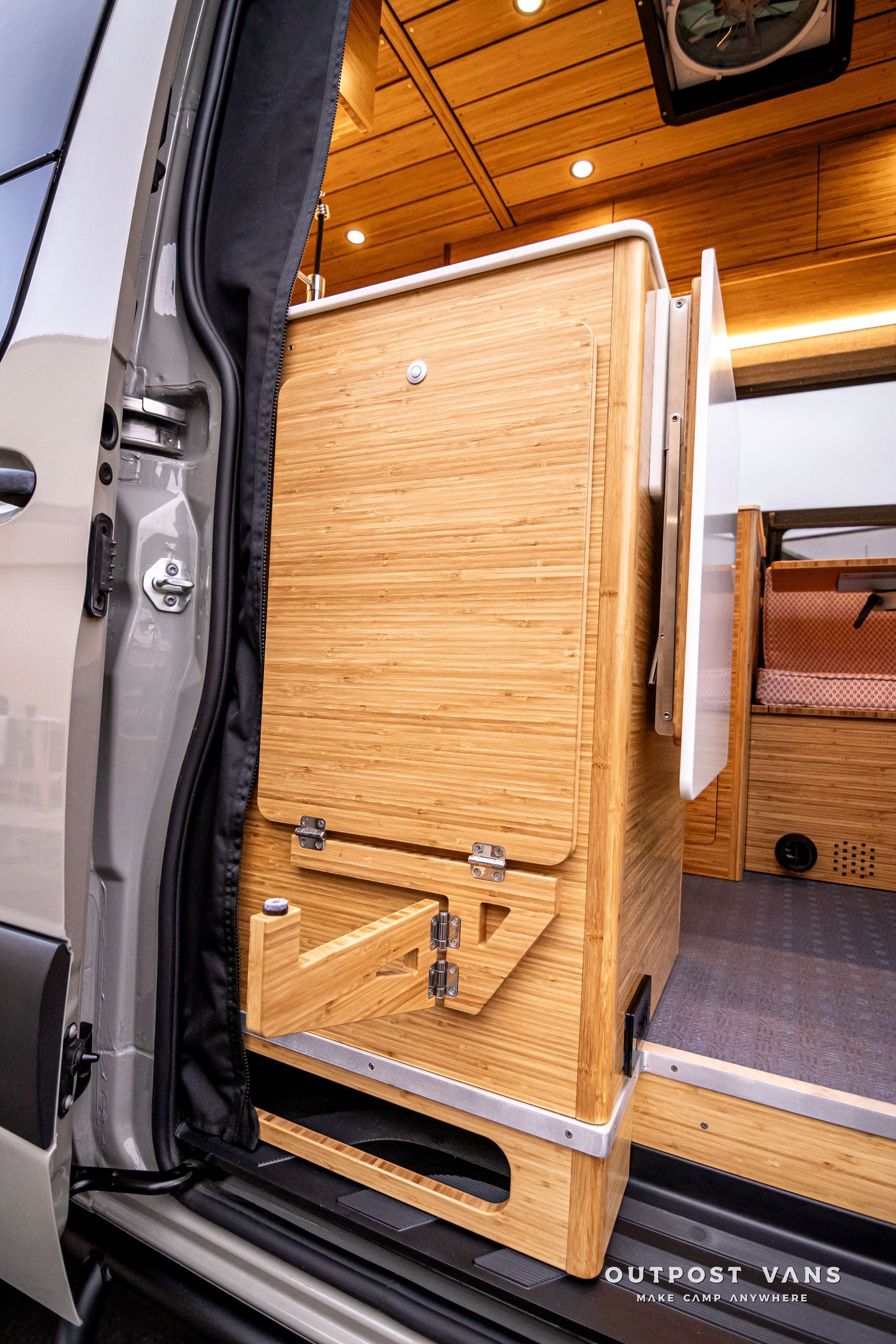 A wooden cabinet is sitting in the back of a van.