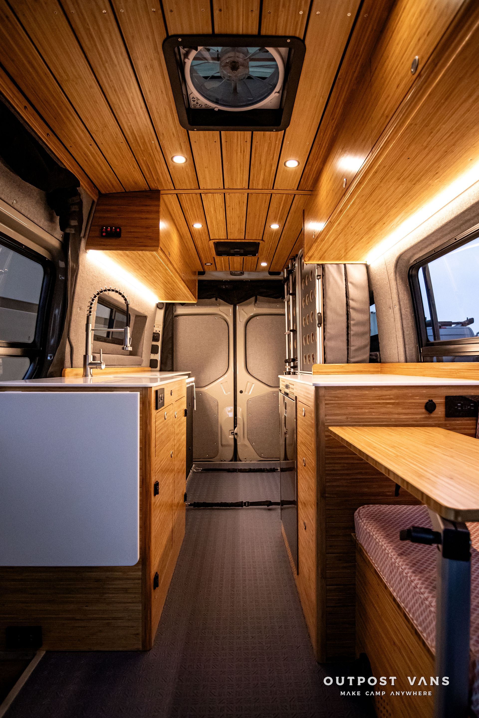 The inside of a camper van with a fan on the ceiling.