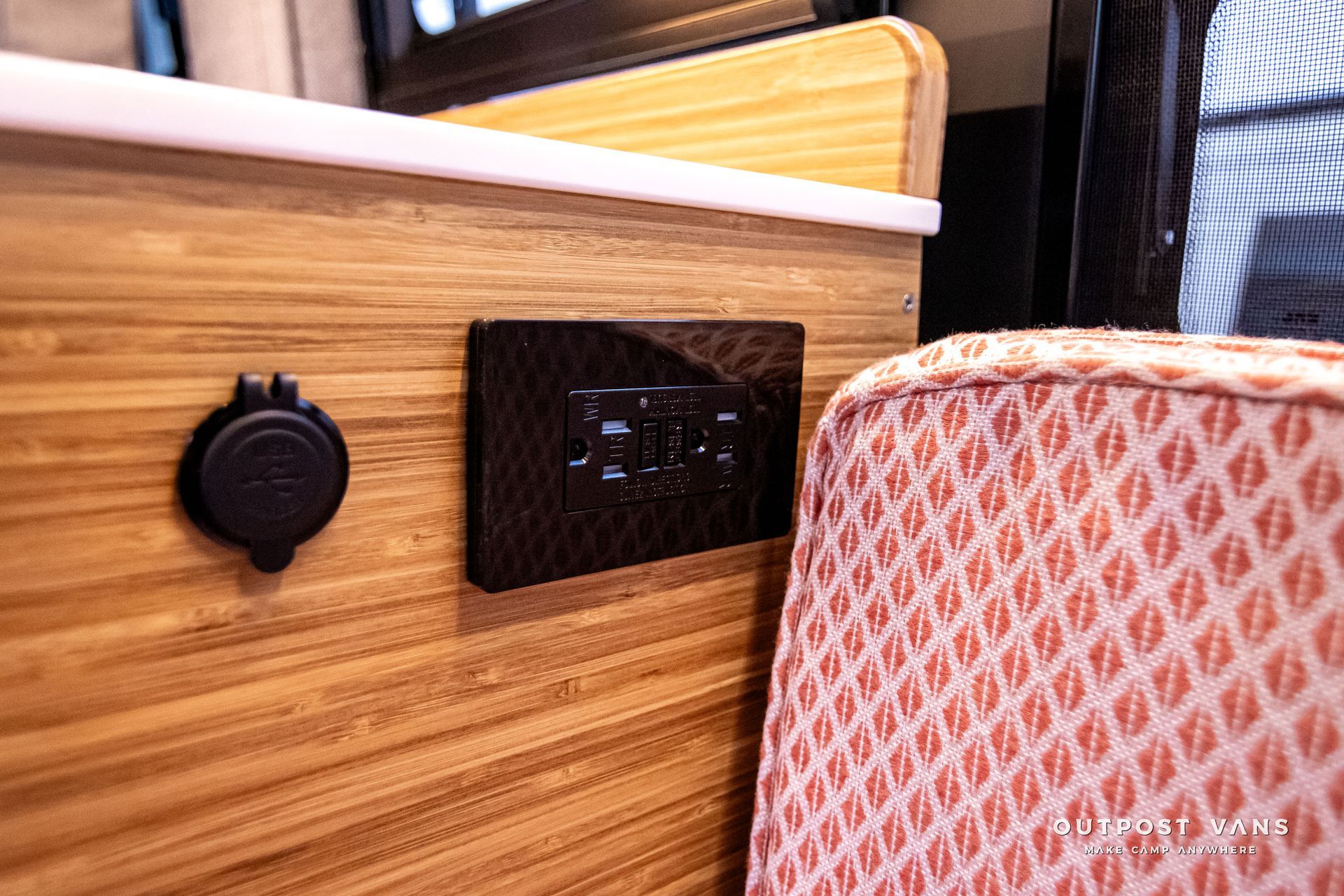 A close up of a charger on a wooden wall next to a chair.