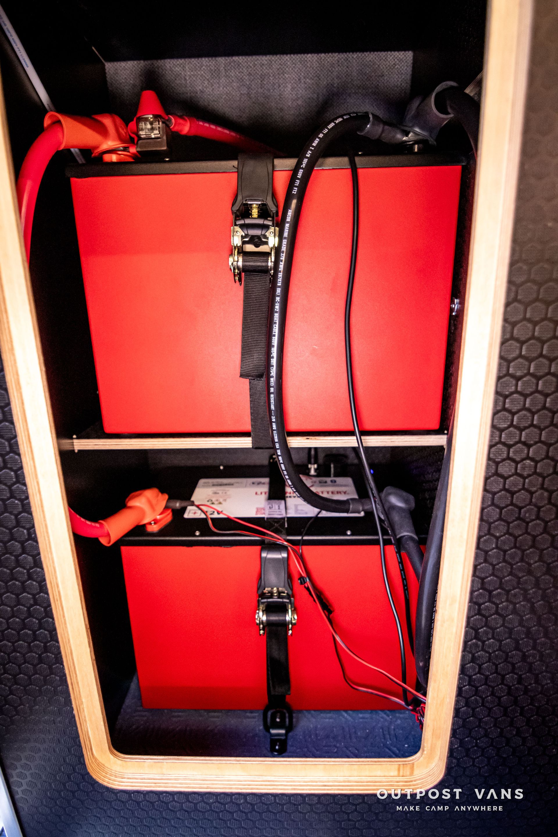 Two red batteries are sitting on top of each other in a van.